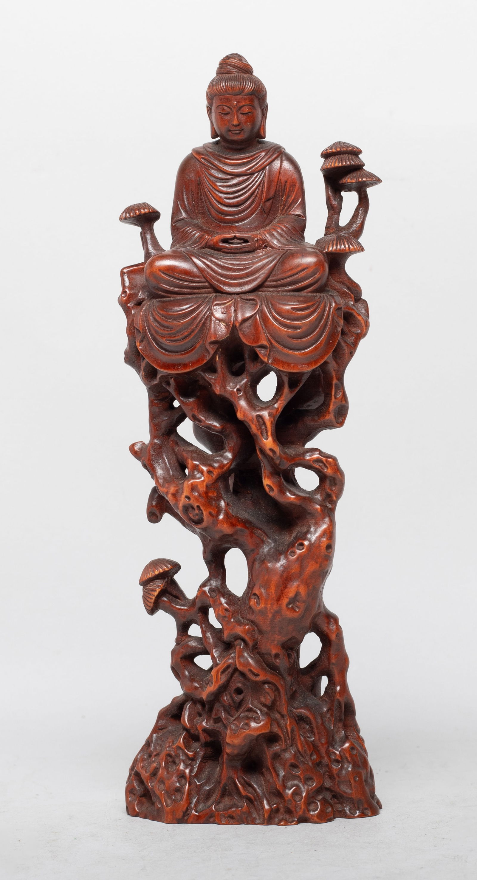 Chinese Export Wood Sculpture of Buddha: The Buddha carved seated on tall gnarled twisted branches issuing mushrooms, the hands in dhyana mudra, wearing a loose-fitting robe. Approx. 8.4*2.9*1.9 inch.