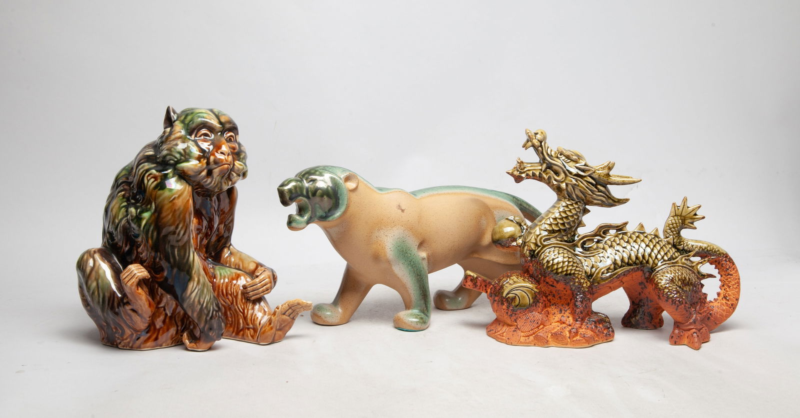 Set Vintage Asian Glazed Porcelain Sculptures: Set of three Asian glazed porcelain sculptures, molded of dragon, monkey or leopard form. Approx. 13.5*6*3.5 inch (leopard size).