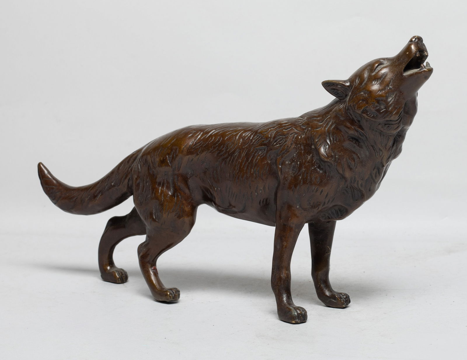 Vintage Mid-century Bronze Sculpture: Vintage bronze table sculpture, cast as a standing wolf with its head looking upward and mouth agape. Approx. 12.2*7.2*2.6 inch. The Estate of the E Los Angeles, 2023.