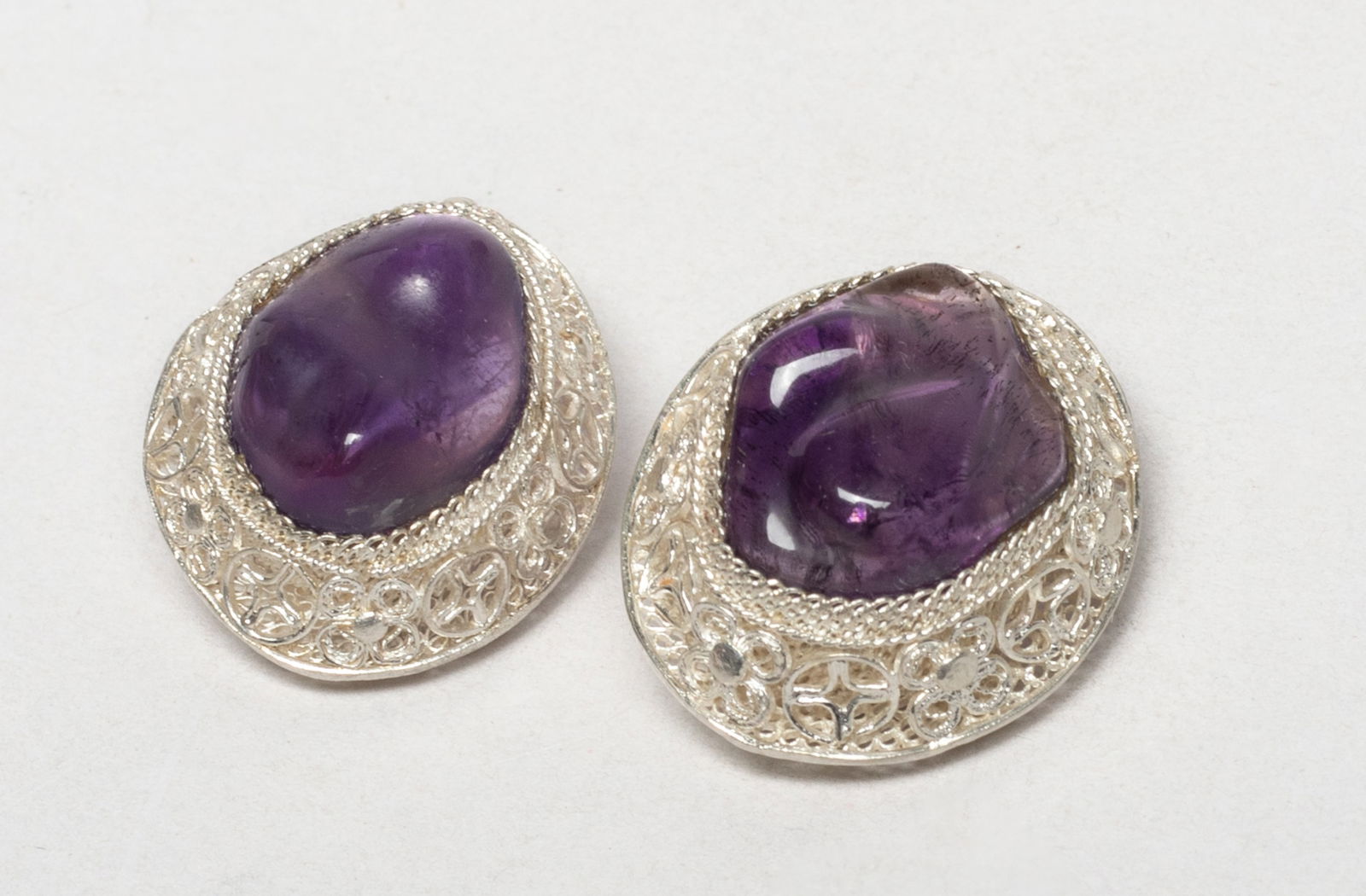 Vintage Chinese Sterling Silver, Amethyst Earrings: A pair of Chinese designed sterling silver earrings inlaid with amethyst. Approx. 9.9 gram (total weight), 0.95*0.8*0.58 inch (each). The Estate of Store Moving Sale, Downtown Los Angeles. 2025.