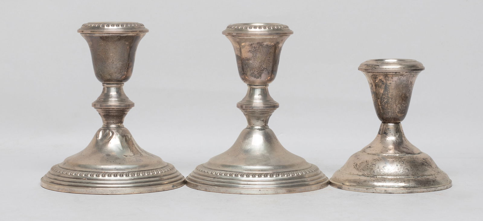 Set Sterling Silver Candlesticks: Set of three sterling silver candlestick holders, each bottom marked Empire STERLING WEIGHTED. Approx. 3.8*4.3 inch (each). The Estate of the E Los Angeles. CA. 2021.