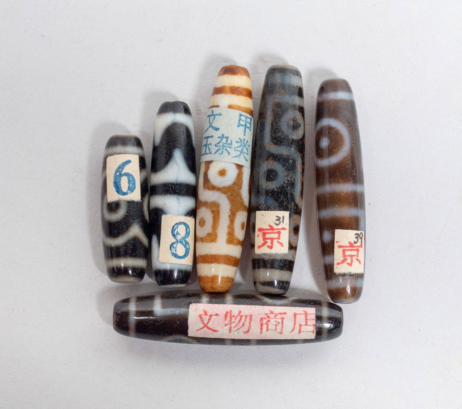 Estate Set Chinese Dzi Beads Collection: Set of six Chinese dzi beads. Approx. 2.3 inch L (longest). The Estate of the F. C. Chung. SF. 2012.