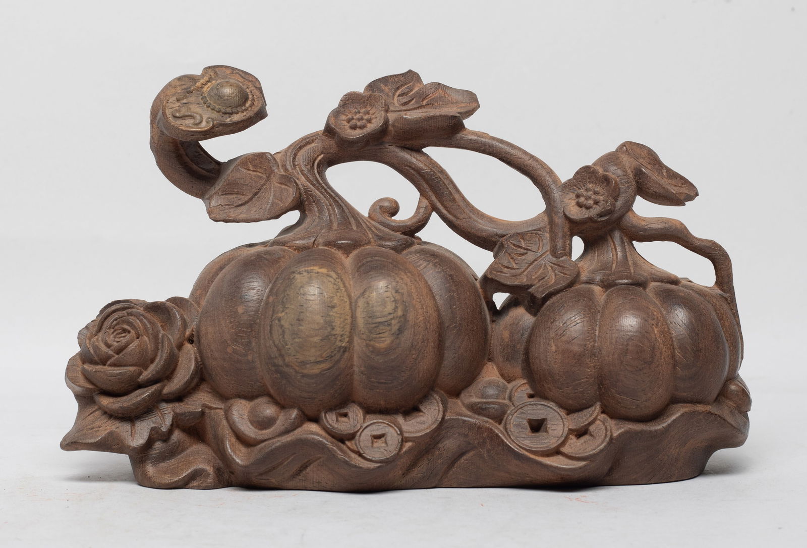 Collectible Chinese Export Agarwood Sculpture: Naturalistically carved as two pumpkins growing from a leafy stem further issuing flowers, a ruyi on the top of pumpkins, all over coins and ingots. Approx. 625 gram, 7*4*3.1 inch.