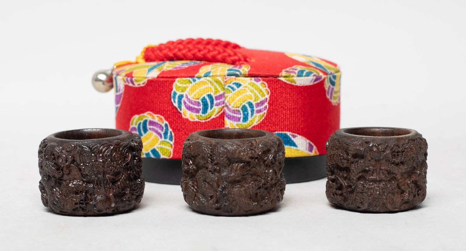 Chinese Export Agarwood Carved Thumb Rings: Set of three Chinese agarwood thumb rings, each carved in raised relief with sinuous draongs, with a box. Approx. 1.4*1 inch (each size), 47 gram (total ring weight).