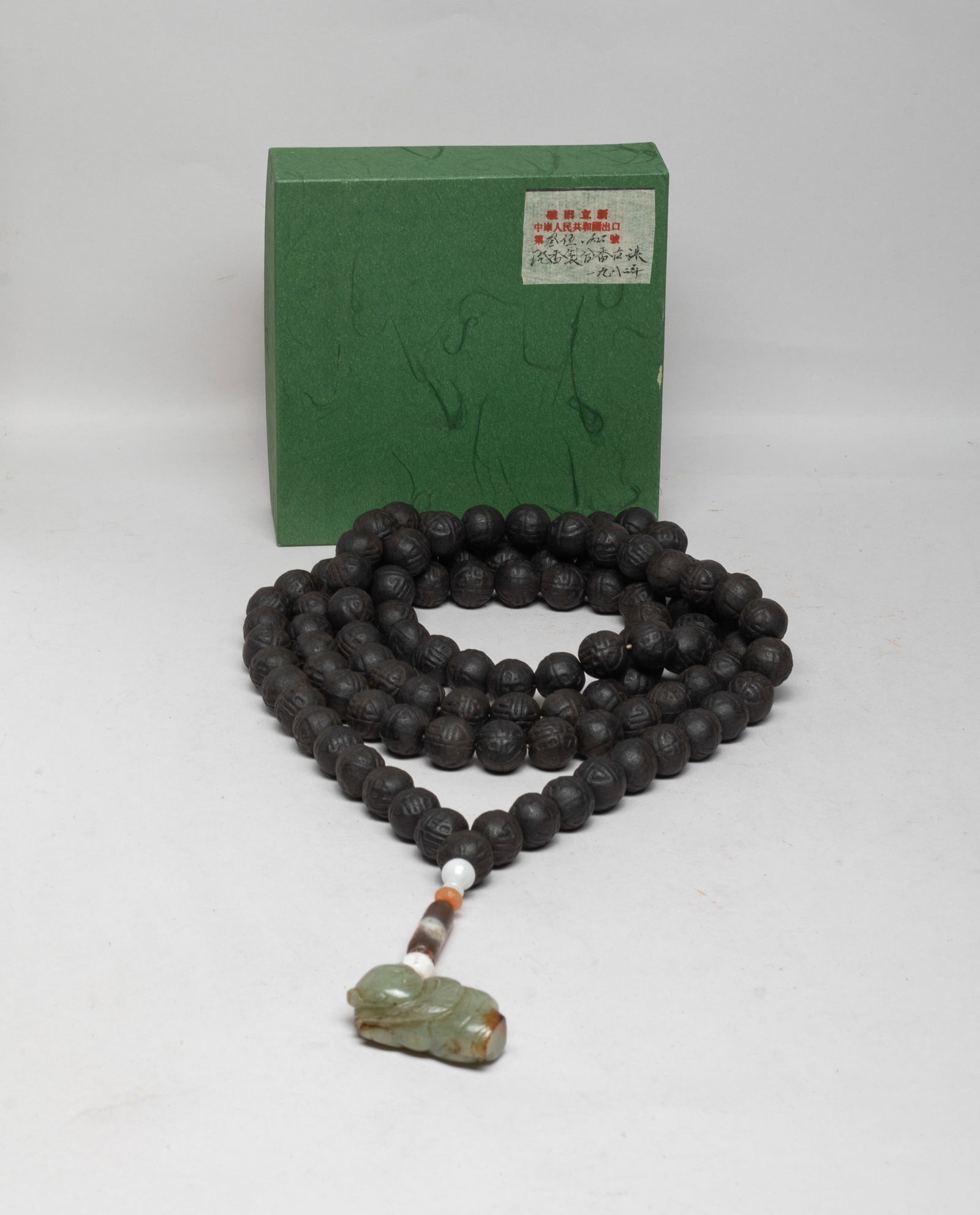 Lg Bead Chinese Mixed Agarwood Hexiang Beads: A long string of Chinese mixed agarwood hexiang prayer beads, with agate beads and a russet jade toggle carved as a boy holding flower. slightly fragrant, with box. Approx. 345 gram (total weight with