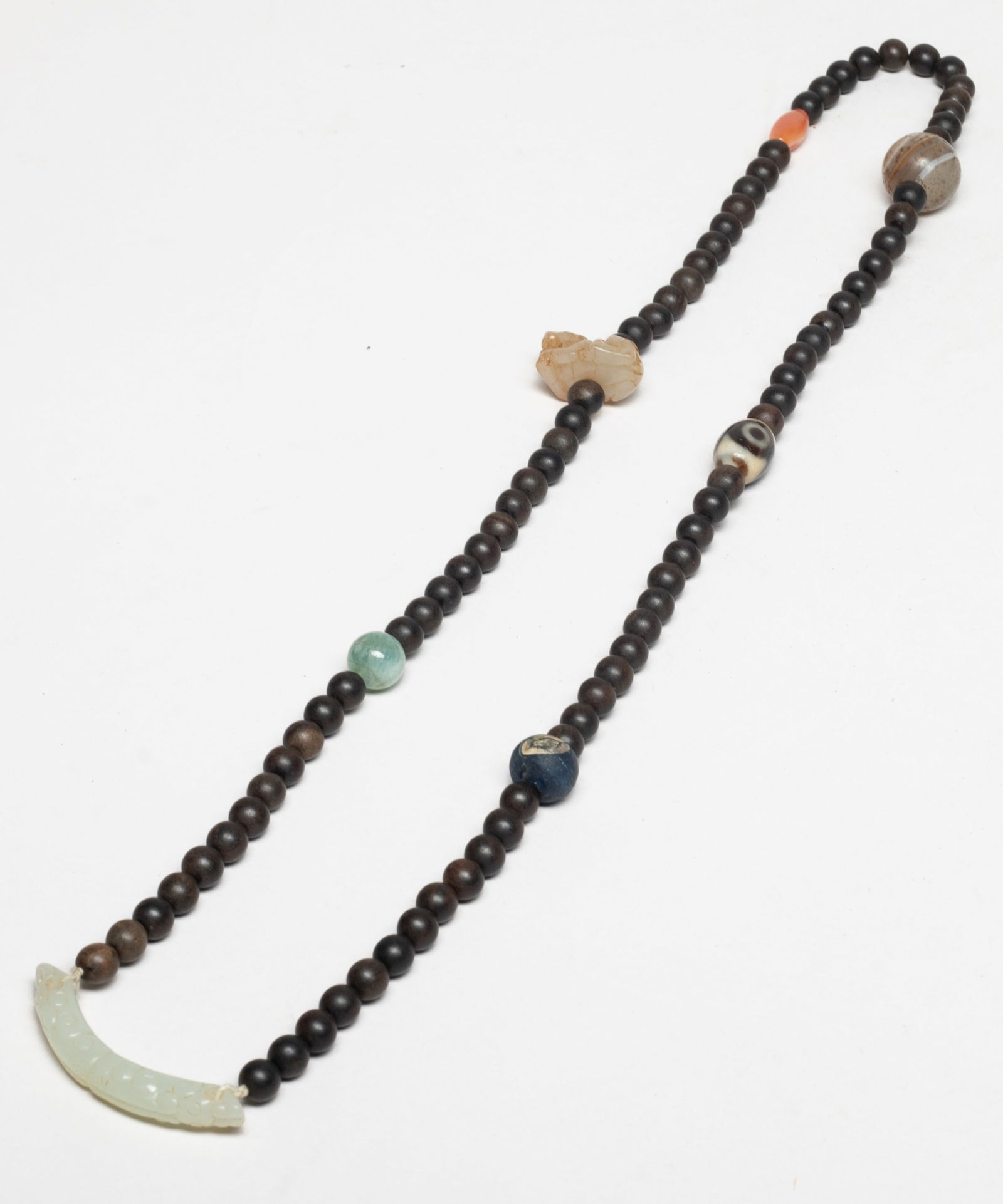 Rare Chinese Jade, Stone, Agarwood Necklace: Chinese agarwood bead necklace, slightly fragrant, with a glass bead, a dzi bead, three gemstone beads, a beast form pendant and a jade pendant. Approx. 30 inch L. The Estate of Store Moving Sale, Dow