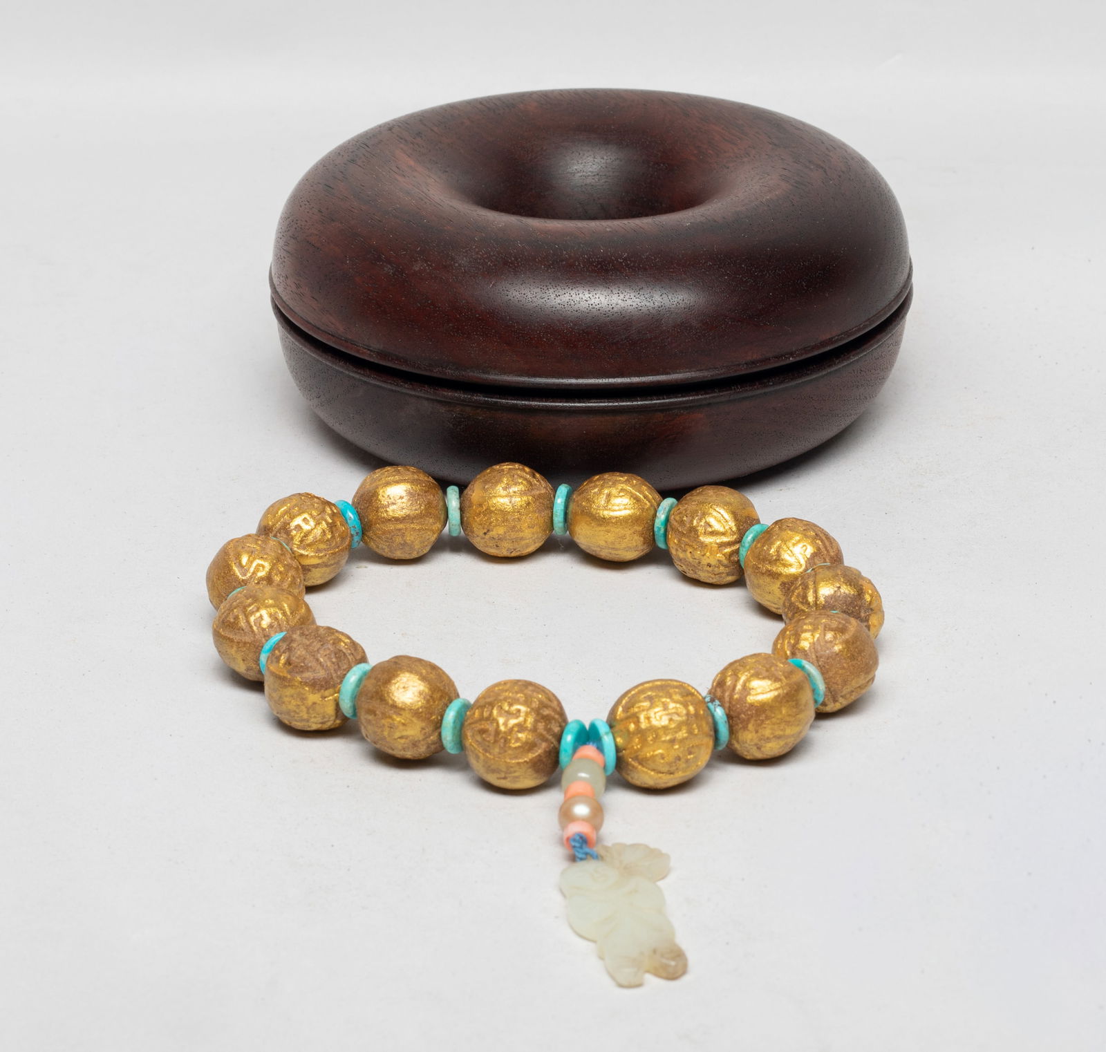Large Bead Chinese Mixed Agarwood Hexiang: A string of Chinese golden-colored mixed agarwood hexiang carved prayer beads, slightly fragrant, spaced by disc beads, terminating with beads and a jade toggle carved as a boy holding lotus, with box