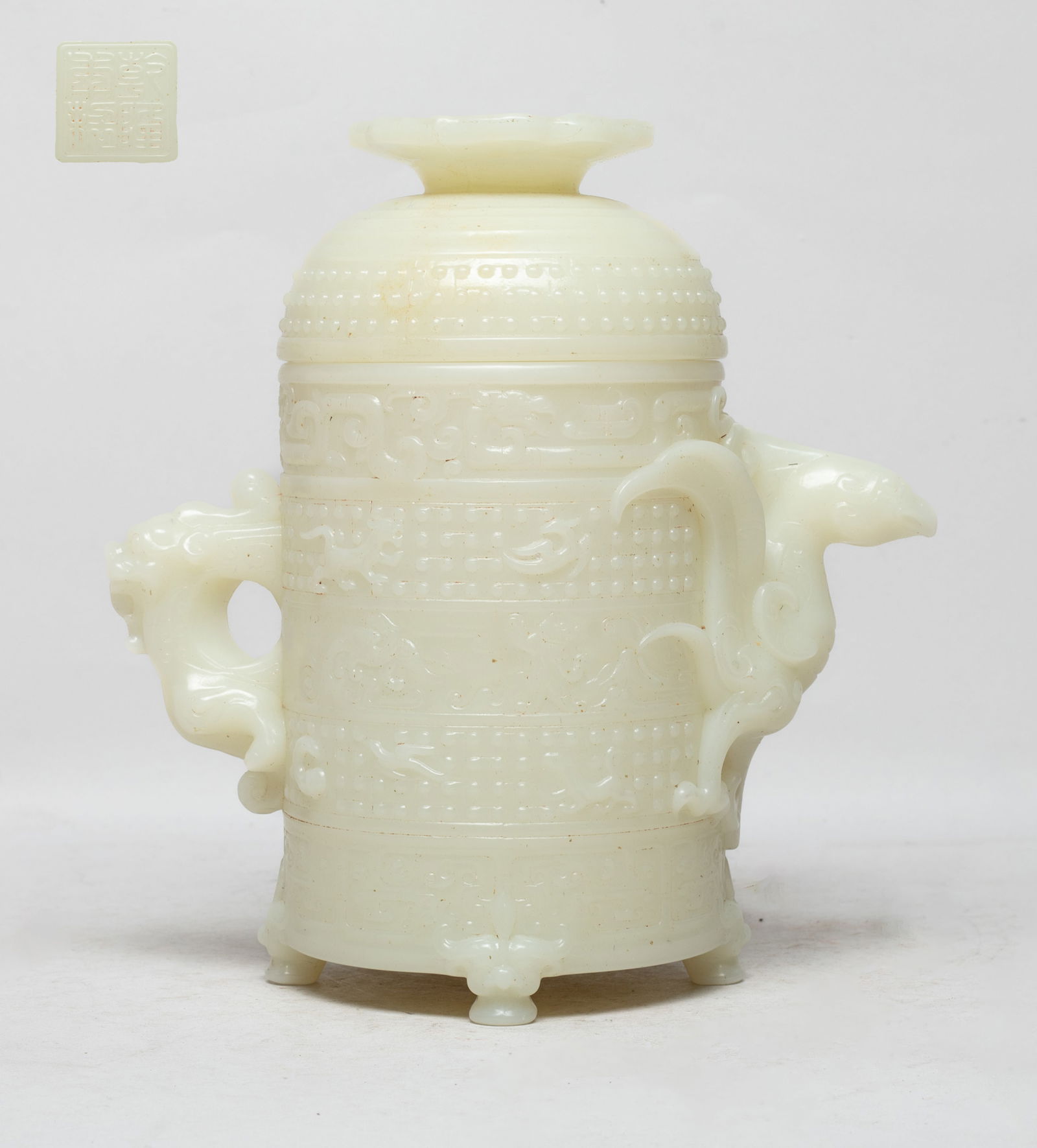 Chinese Export Covered Pot: The cylindrical body exterior carved with bands of stylized beasts, flanked by two handles carved of phoenix or dragon form, the bottom inscribed with a seal mark, the domed lid carved with raised