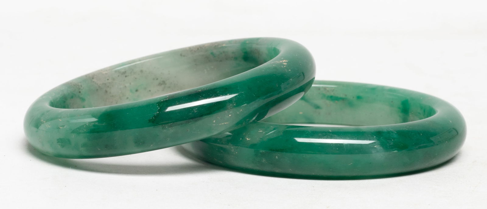 Estate Two Chinese Export Jade Bangles: Two Chinese jade carved bangles. Approx. 3.07 inch outer diameter, 2.33 inch inner diameter (larger). The Estate of S Pasadena, CA, 2024.