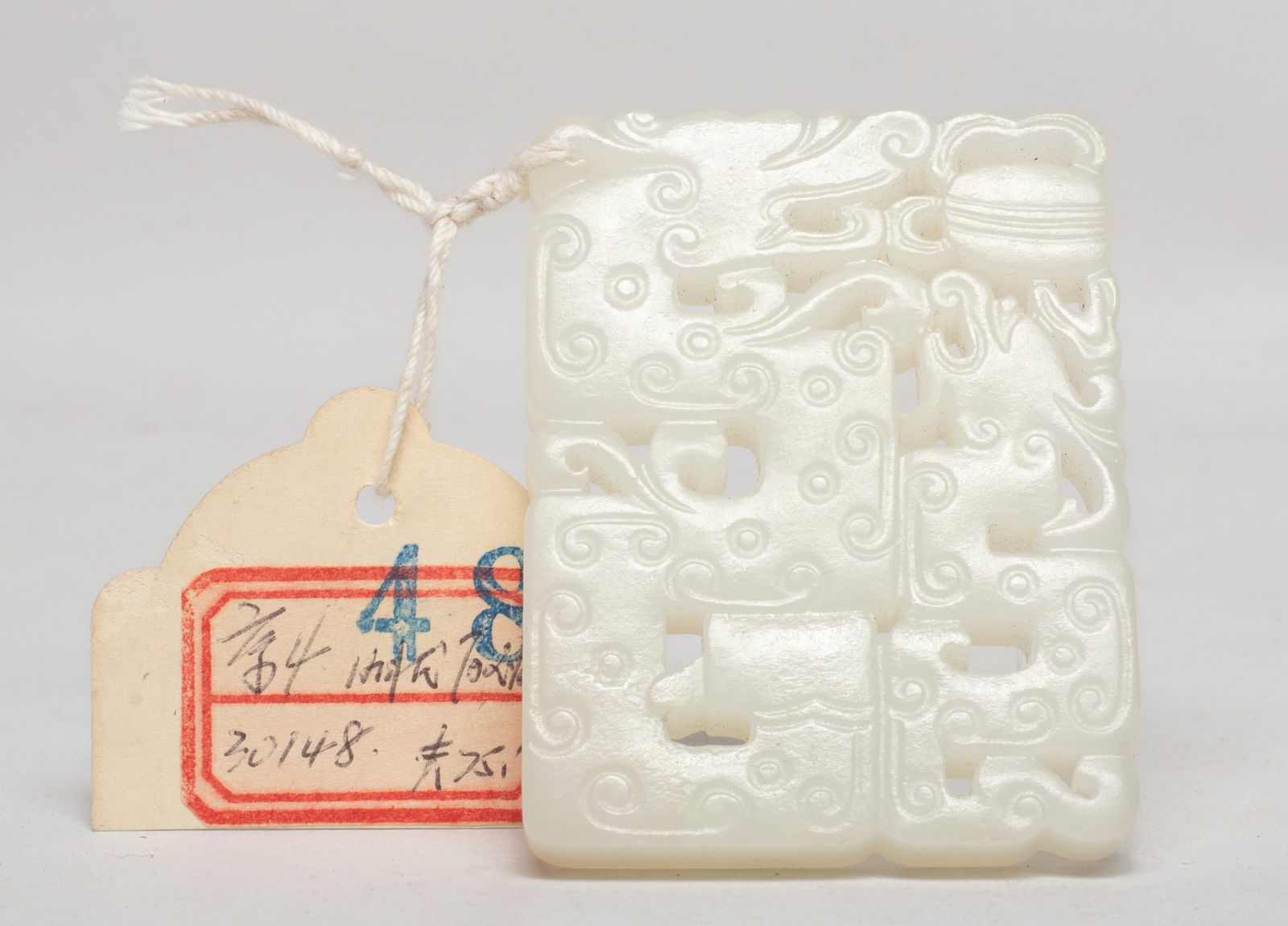 Chinese White Jade Plaque: Of rectangular shape, carved in openwork with two S-shaped dragons pursuing a beribboned ball, the dragon body incised with scrolls. Approx. 2.35*1.83 inch.