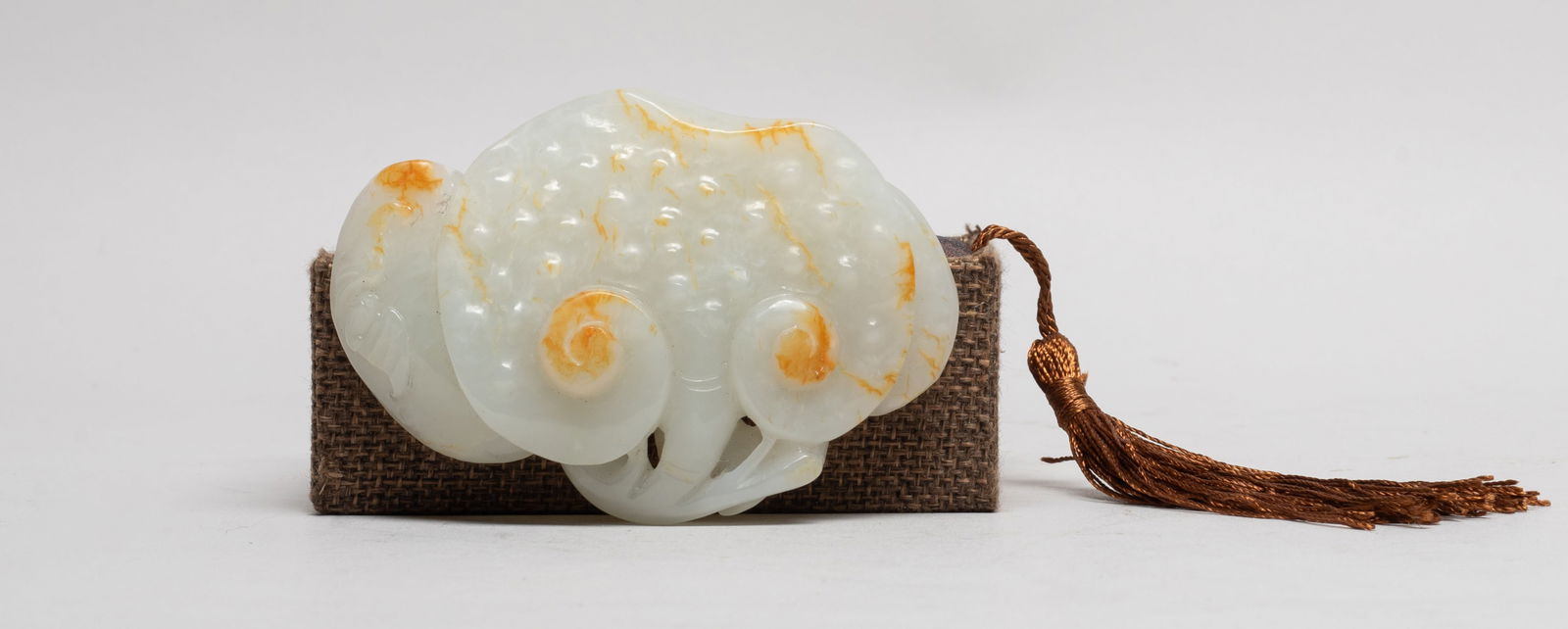 Large Chinese Russet White Jade Pendant: Naturalistically carved as three lingzhi fungus issuing from a short stem, a bat on the left fungus, the jade of white tone with russet inclusions, with box. Approx. 3.55*2.45*0.75 inch (w/o box).