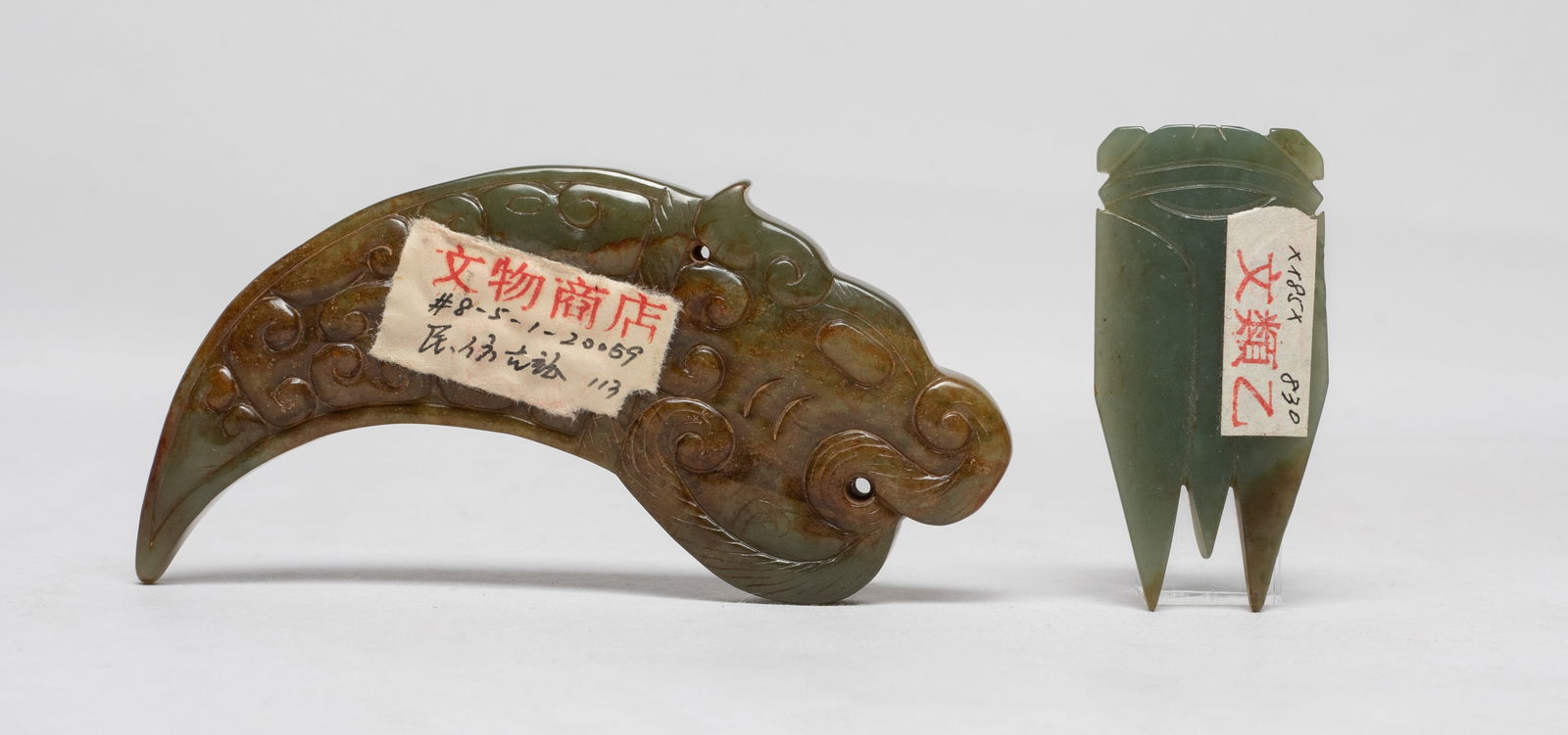 Two Chinese Jade Carved Pendants: Two celadon and russet jade pendants, one carved cicada form, the other carved of mythical beast form, the pointed body detailed with C-shaped scrolls, drilled at the neck and mouth for suspension.
