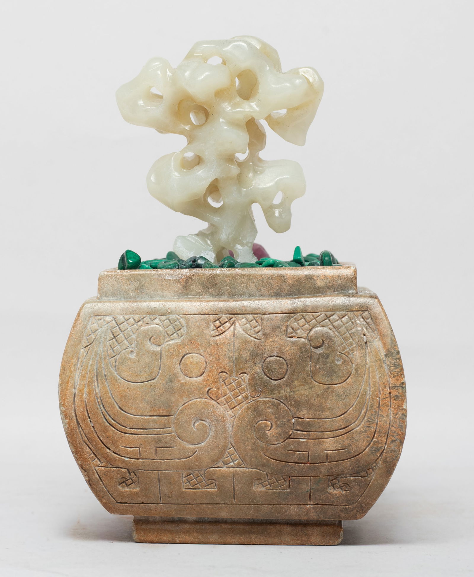 Estate Chinese Jade, Stone Bonsai: Chinese jade bonsai carved and reticulated of scholar stone form, with a stone pot incised with taotie masks and archaic birds on the sides, with malachite and pink gemstone pieces. Approx. 5*3.3*3 in
