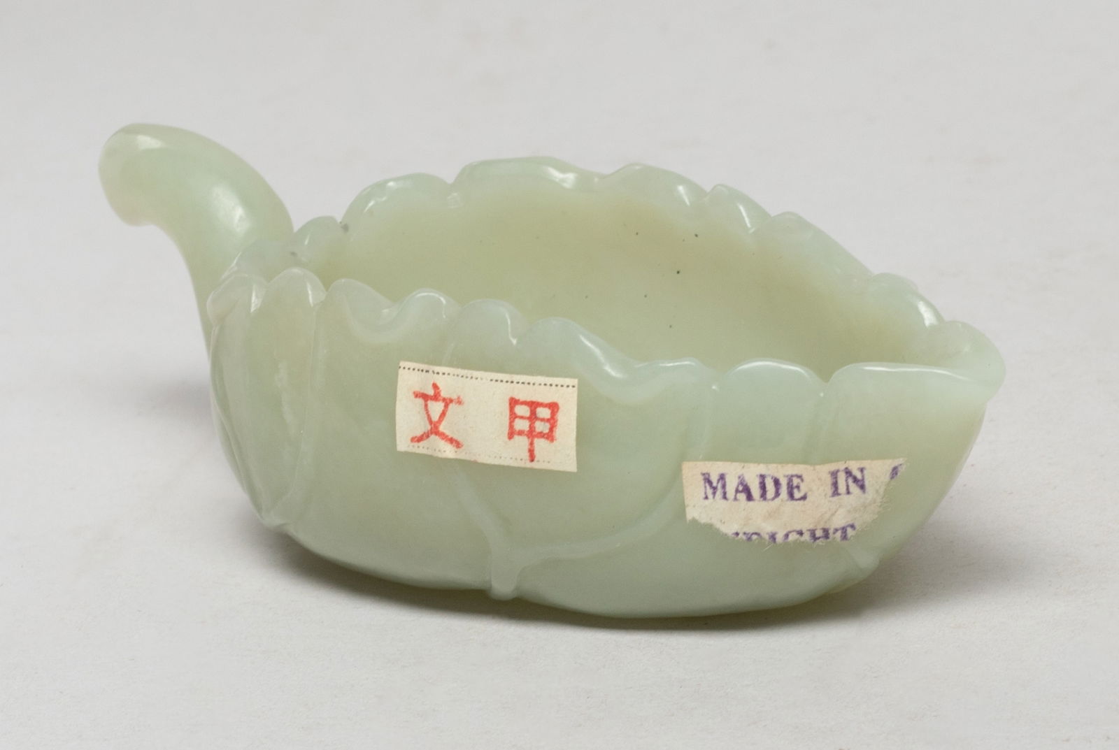 Chinese Jade Carved Washer/ Pot: Chinese pale celadon jade washer / pot carved of leaf form with a stem form handle. Approx. 4.15*1.85*1.3 inch. The Estate of E Los Angeles, CA. 2022.