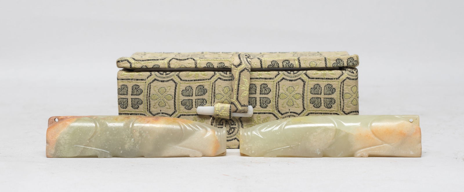 Two Chinese Russet Jade Sculptures of Pig: The finely polished stone carved in the form of a recumbent pig with a flat snout and pointed ears, the body carved with deep slanting grooves delineating the front and rear legs. Approx. 3.5*0.78*0.7