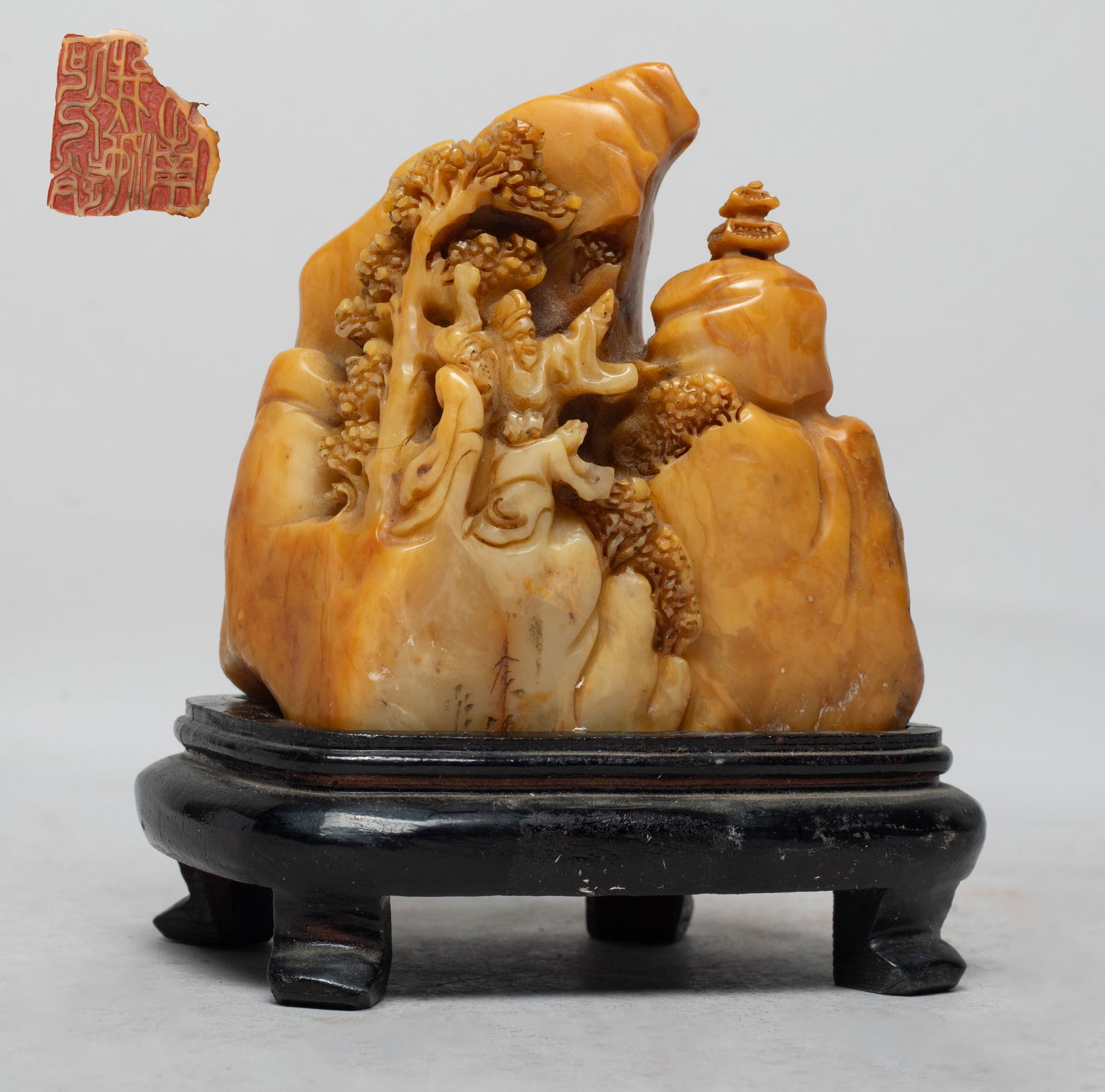 Rare Chinese Shoushan Stone Seal Sculpture: Carved in varying levels of relief with two sages and an attendant travelling along a mountain path beneath a gnarled tree, wherein one scholar pointing at a distant pavilion, with stand. Approx. 5*4.