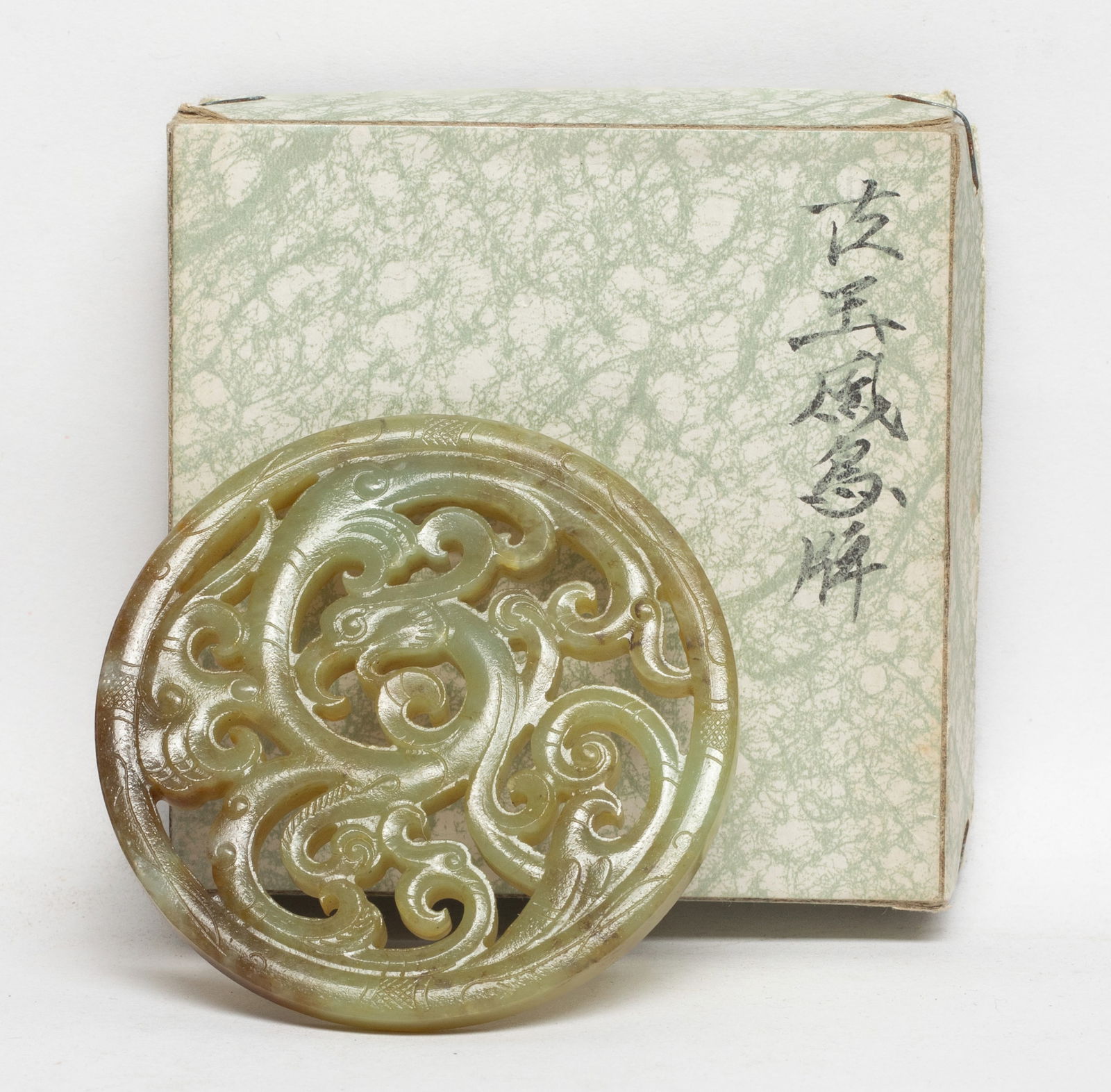 Chinese Export Jade Carved Pendant: Chinese russet jade plaque of circular shape, carved in openwork with a stylized phoenix. Approx. 2.55 inch D. The Estate of E Los Angeles, CA. 2022.