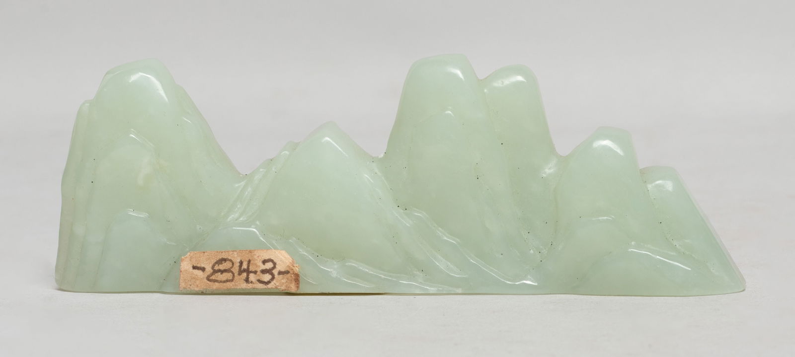 Chinese Jade Carved Brush Stand: Collectible Chinese jade carved brush stand, carved in the shape of mountain range. Approx. 4.07*1.35*0.65 inch. The Estate of E Los Angeles, CA. 2022.