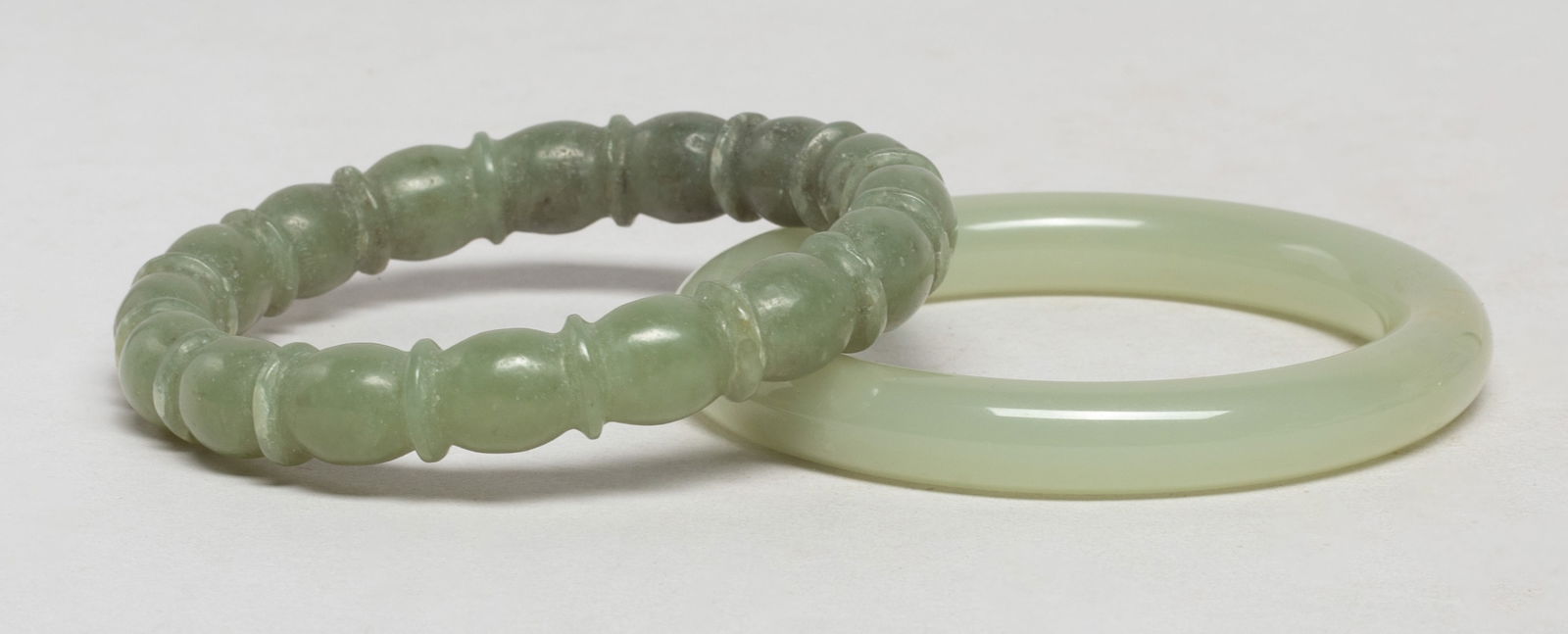 Two Vintage Chinese Export Jade Bangles: Two vintage Chinese jade bangles. Approx. 3.12 inch outer diameter, 2.23 inch inner diameter (larger). The Estate of S Pasadena, CA, 2024.