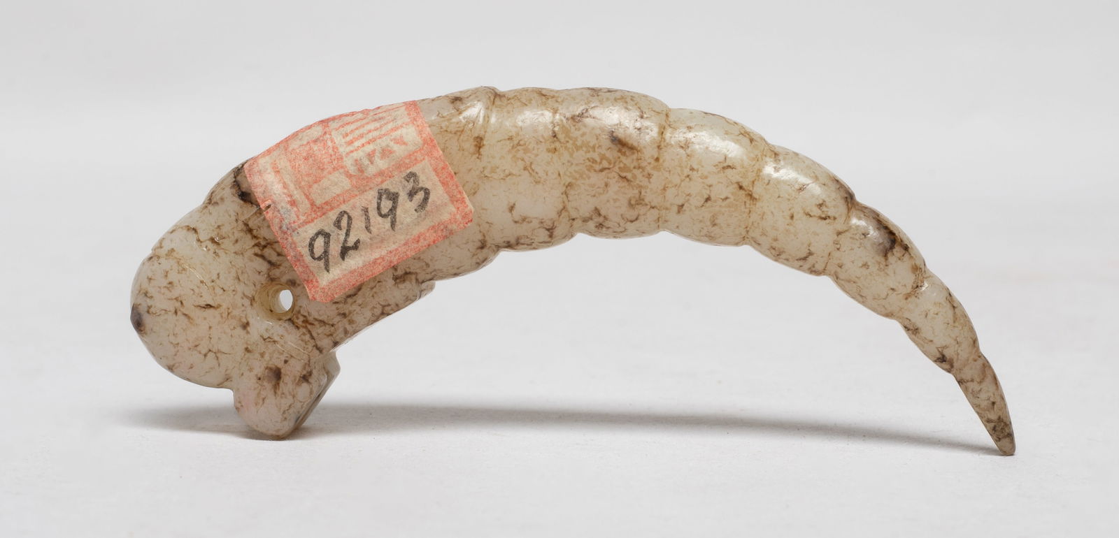 Chinese Long Jade Pendant: Special form Chinese russet jade pendant, the mythical beast carved with a rounded head and a segmented body. Approx. 3.85*0.95*0.6 inch. The Estate of the F. C. Chung. SF. 2012.