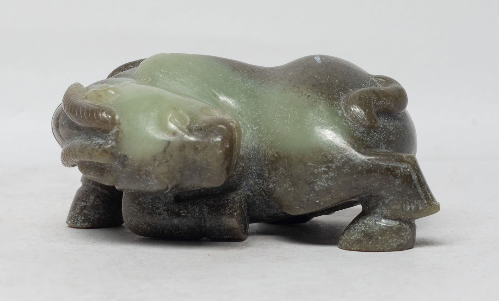 Large Chinese Russet Jade Beast Sculpture: Exquisitely carved in the round with the recumbent beast, the head turned back over its left flank, two horns extending over its neck. Approx. 4.2*2.9*2 inch. The Estate of S Pasadena, CA, 2023.