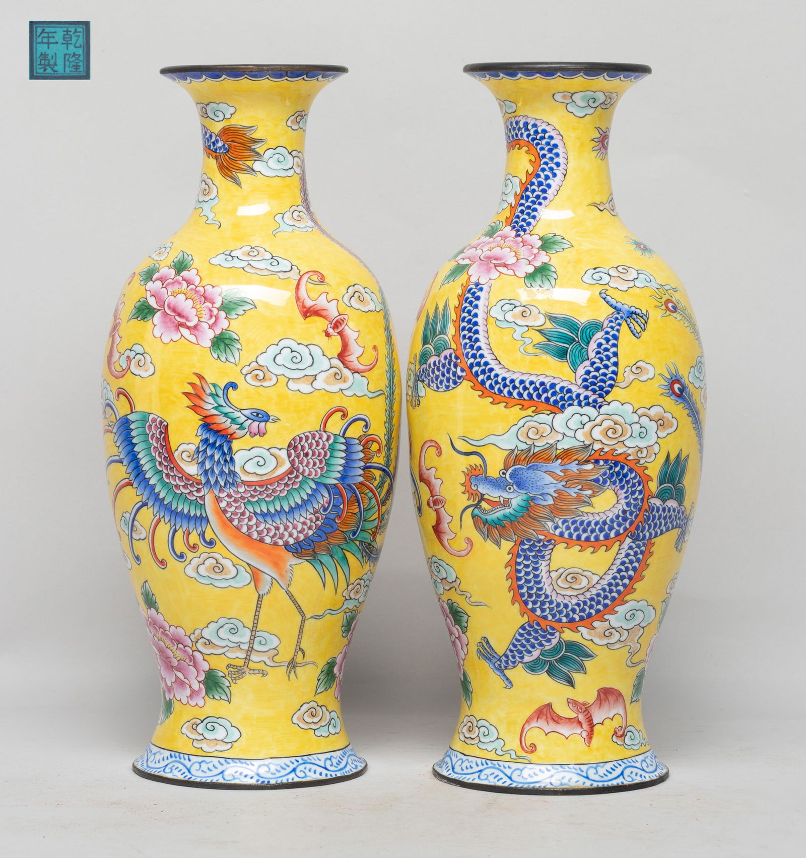 Two Chinese Enameled on Copper Vases: Each vase exterior enameled with a dragon, a phoenix and bats amidst flowers and clouds on yellow glazed background, the interior and bottom turquoise glazed, the bottom with a seal mark. Approx. 9*3.