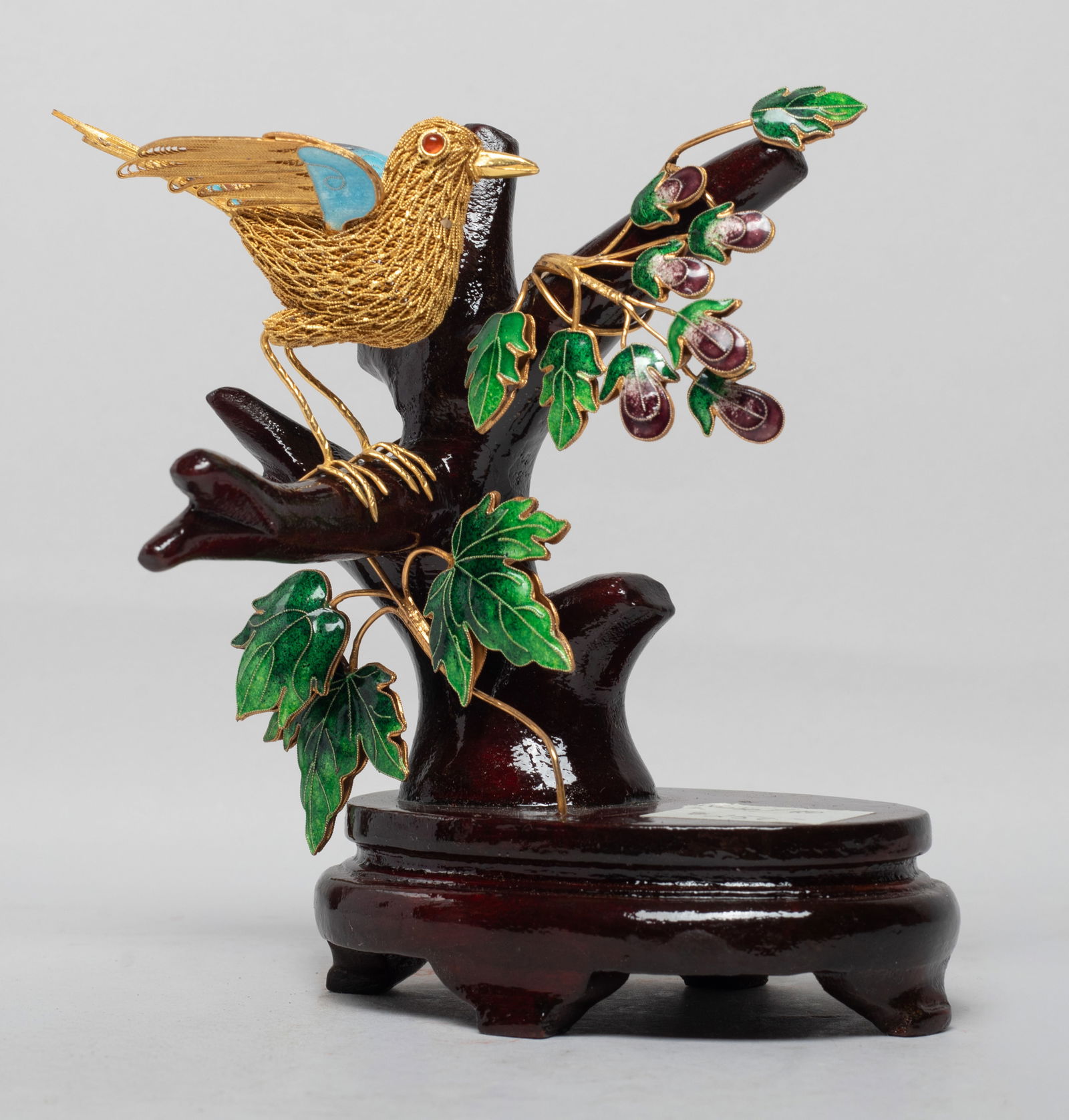 Vintage Chinese Gold on Sterling Silver Sculpture: Chinese gold on sterling silver sculpture molded as a bird on a tree, the bird wings and tail applied with blue, purple and brown glaze, the tree with green glazed leaves and purple glazed fruits, wit