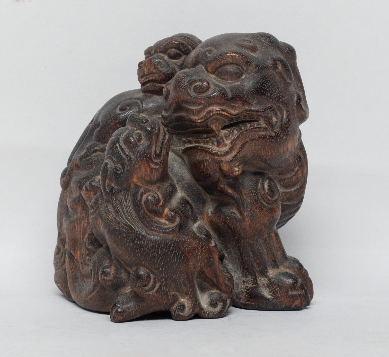 Chinese Agarwood Beast Sculpture: Carved as a crouching beast with its head turning backward, with bulging eyes, wide nostril and agape mouth, two young beasts clambering over its body. Approx. 140 gram, 3.6*3*3 inch. The Estate of th