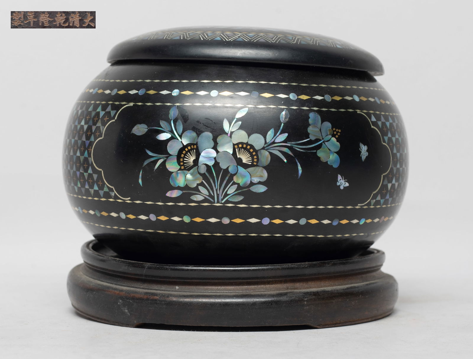 Chinese Lacquer Inlaid MOP Chess Box: The box body inlaid with mother-of-pearl and carved as flowers and butterflies, the lid inlaid with mother-of-pearl and carved with flowers and birds, the bottom marked with six characters, with stand