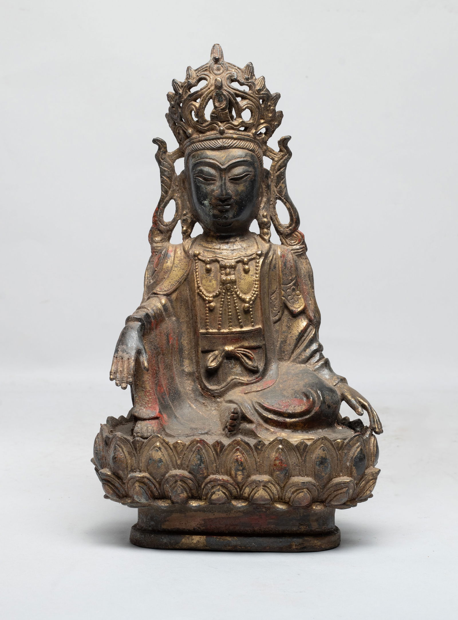 Chinese Painted Bronze Sculpture of Buddha: The Buddha cast seated on a lotus throne, the hands resting over knees, wearing a loose fitting robe, decorated with a diadema and a beaded necklace. Approx. 10.8*6.2*4.2 inch. The Estate of the E Los
