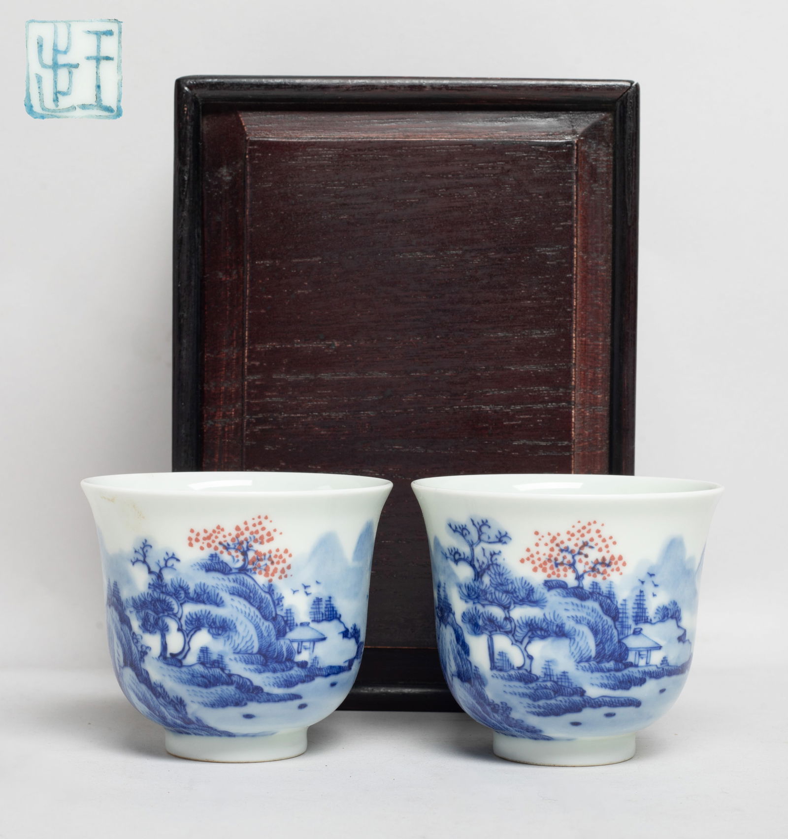 Two Chinese Blue & White Porcelain Tea Cups: Each cup exterior painted with continuous landscape scene, the bottom with a seal mark, with box. Approx. 2.8*2.4 inch (each cup size). The Estate of the Miura, Ventura, CA, 2020.