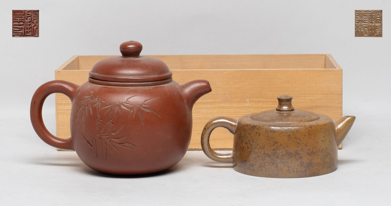Two Vintage Chinese Zisha Tea Pots: The larger tea pot carved with bamboo and inscribed with poems, both pots incised with two marks on the lid interior, and seal mark on the pot bottom. Approx. 6.2*4.4*4.1 (larger). The Estate of Downt