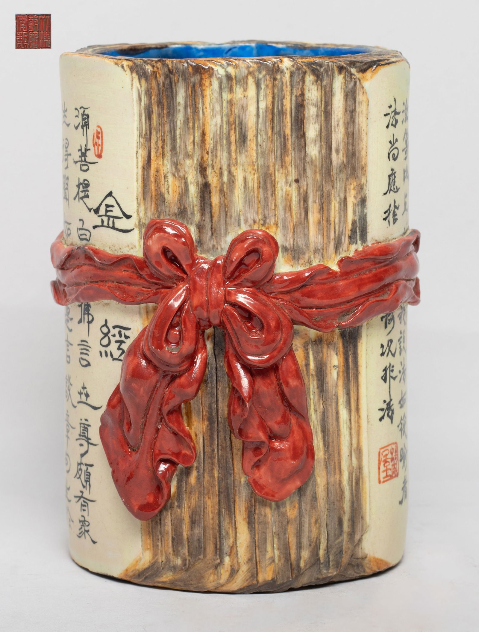 Chinese Export Flambe Glazed Porcelain Brush Pot: Molded in form of an open book beribboned by a red glazed scarf, inscribed with Buddhist texts and marks, the interior and bottom blue glazed, incised with a six-character on the bottom. Approx.4*5.7