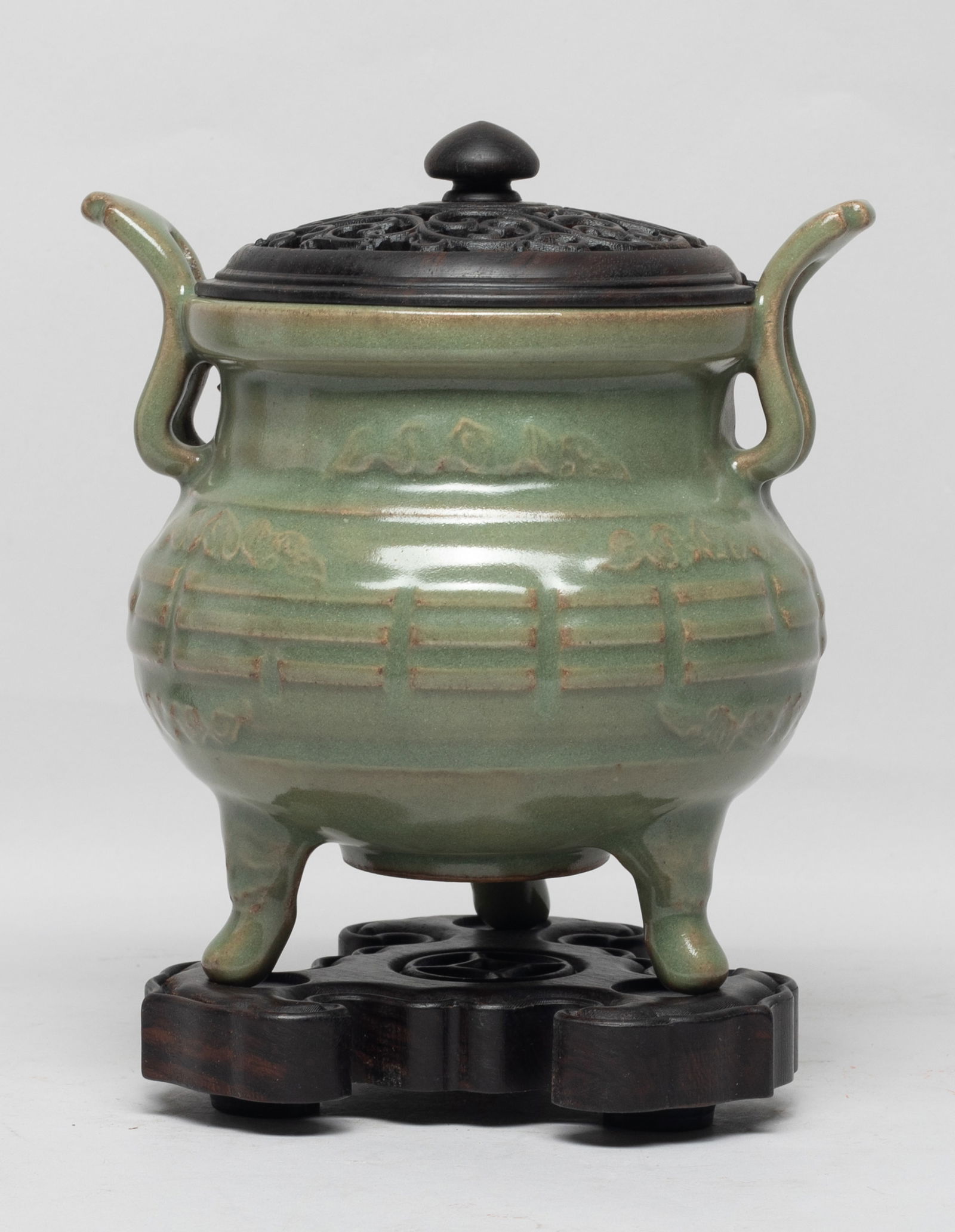 Chinese Longquan Porcelain Cabinet Censer: The compressed globular body rising to a broad neck and a dished rim, flanked by two curled handles, all supported on three cabriole legs, the exterior carved with Daoist Eight Trigrams and clouds, th