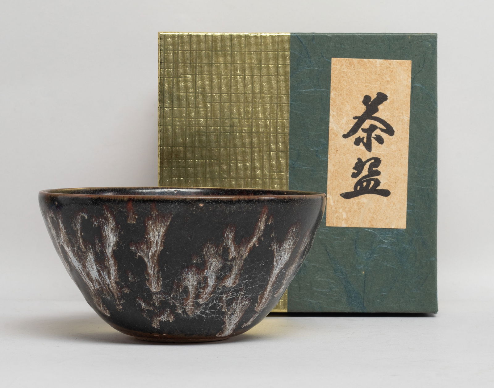 Chinese Jichou Ware Porcelain Tea Bowl: The interior decorated with three stylized paper-cut beasts scattered over a variegated glaze of mottled grey and light chestnut tones, the exterior covered with a dark brown glaze with white streaks