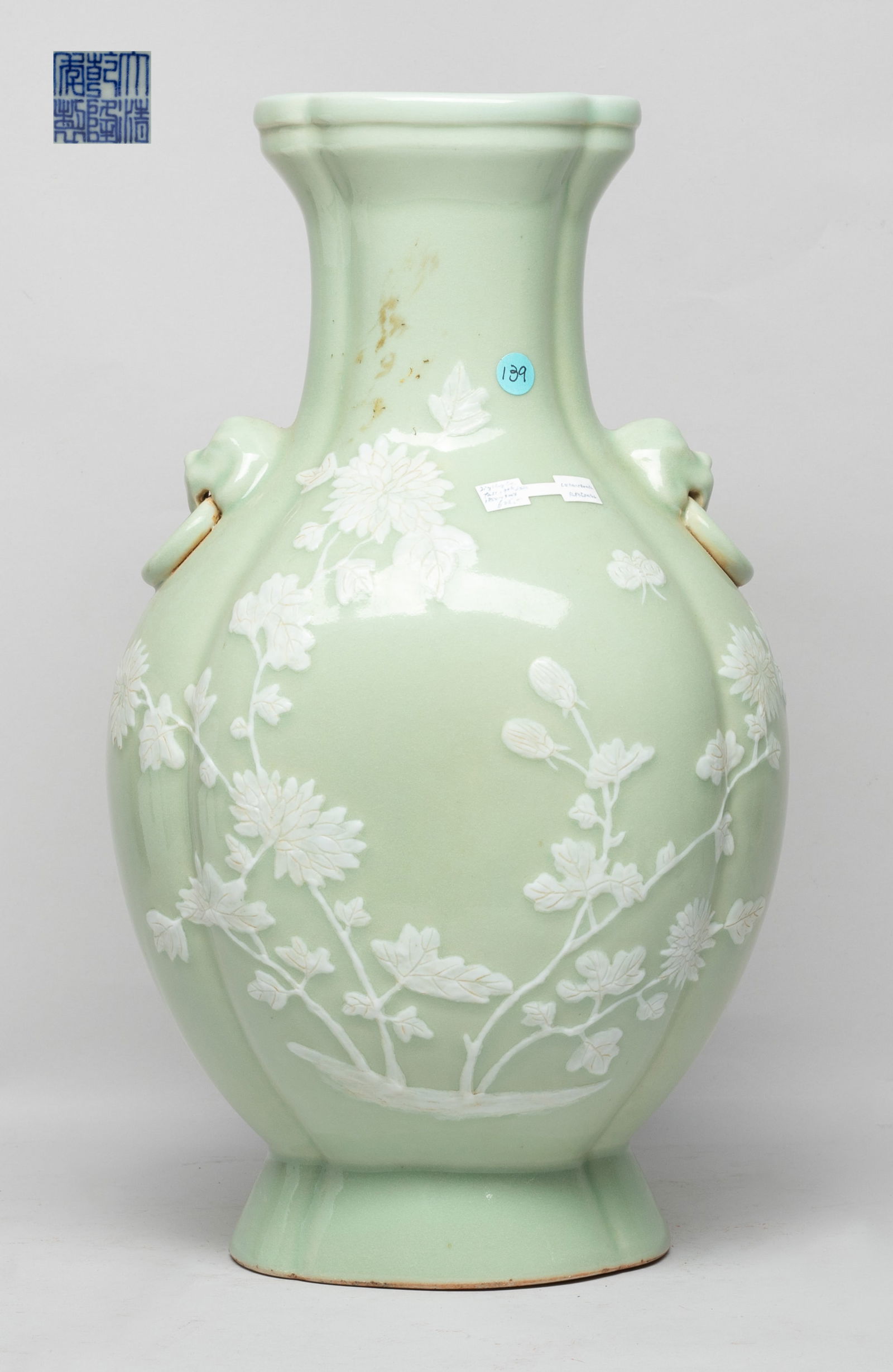 Tall Chinese Export Porcelain Vase: Of ruyi head section, the ovoid body rising from a splayed foot to a waisted neck, flanked by two faux-ring mask handles, the exterior carved with a butterfly and chrysanthemum on one side, and two ba