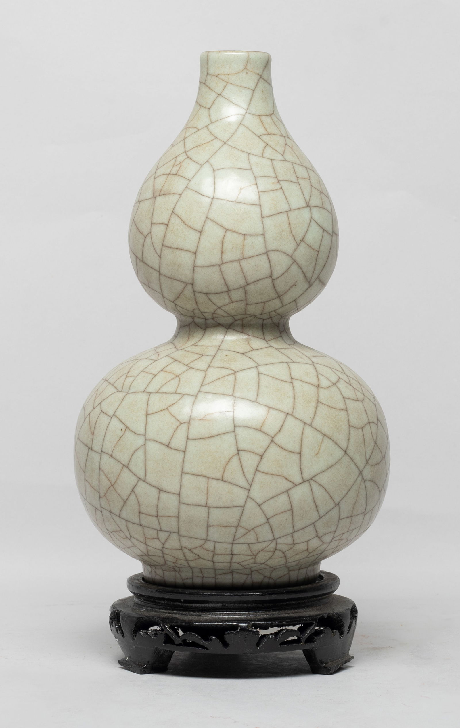 Chinese Crackle Glazed Porcelain Gourd Vase: Of double gourd form, overall covered in mottle gray glaze suffused with a matrix of dark brown crackles, with stand. Approx. 8.6*5 inch (w/o stand). The Estate of the Consignment Store Closed Sale. L