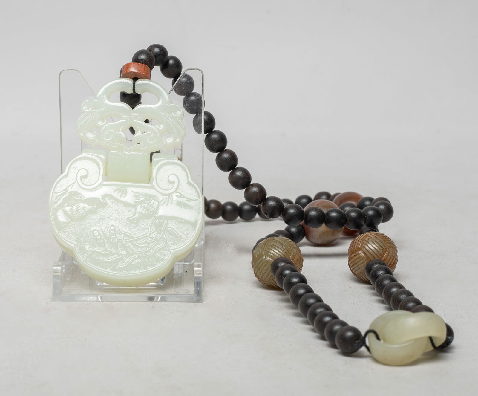 Estate Chinese Agarwood Necklace w/ Jade, Agate: Long Chinese agarwood bead necklace, with two jade beads, two agate beads and two interlocking loops, suspended with a white jade pendant of ruyi head shape, carved with a pair of birds and reeds, the
