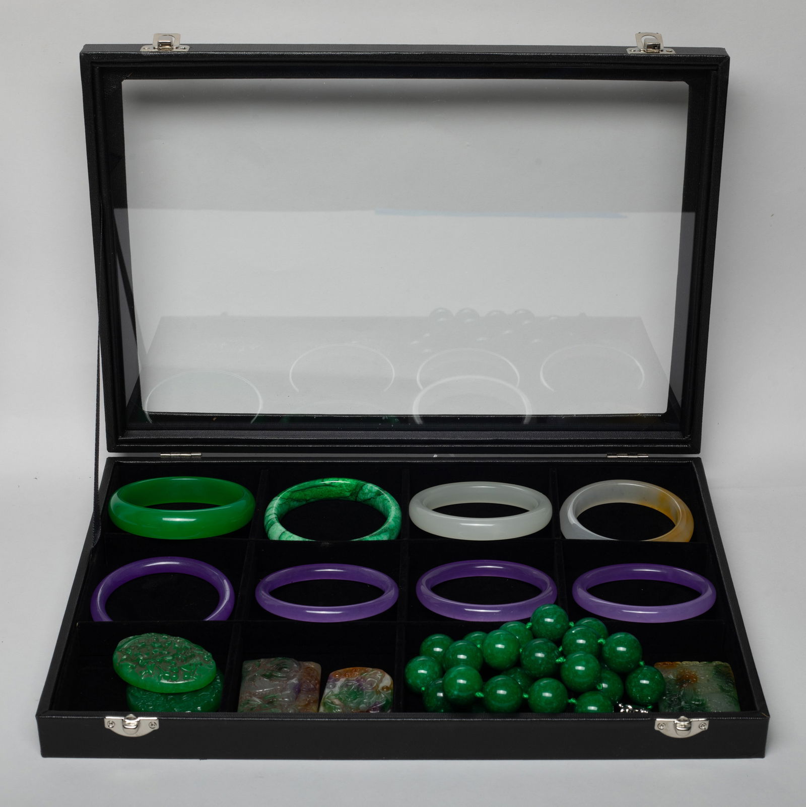 Estate Box of Chinese Export Colored Stone Jewelry: Including eight colored stone bangles, five pendants, and a bead necklace, the pendants carved with dragon, flower, Buddha, or lotus & carp, with case. Approx. 20 inch L (necklace size).