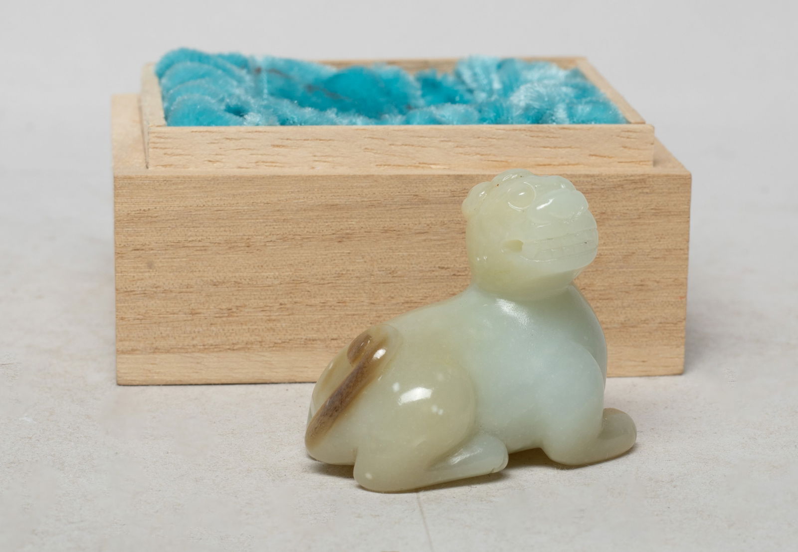 Chinese Jade Carved Beast Toggle w/ Box: Chinese russet jade toggle carved of recumbent beast form, its four legs tucked under its body, the beast head turned to the right, drilled through the mouth, with a lidless box. Approx. 1.8*1.5*1.05