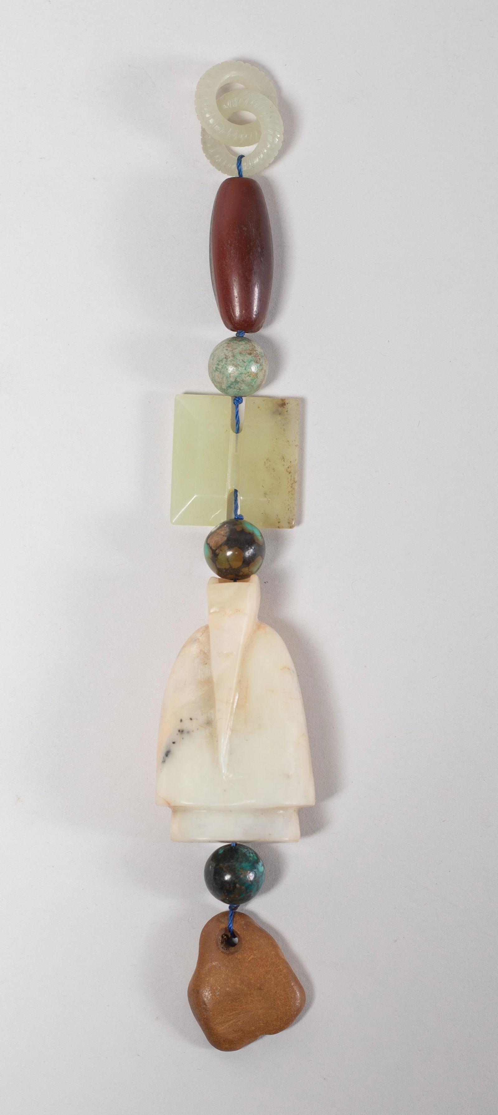 Chinese Jade, Stone, Agate Pendant: Comprised of two interlocking loops, an agate bead, three stone beads, a jade toggle, a large jade carved figure toggle, and a stone toggle. Approx. 2*1.2*0.7 inch (largest). The Estate of the Store C