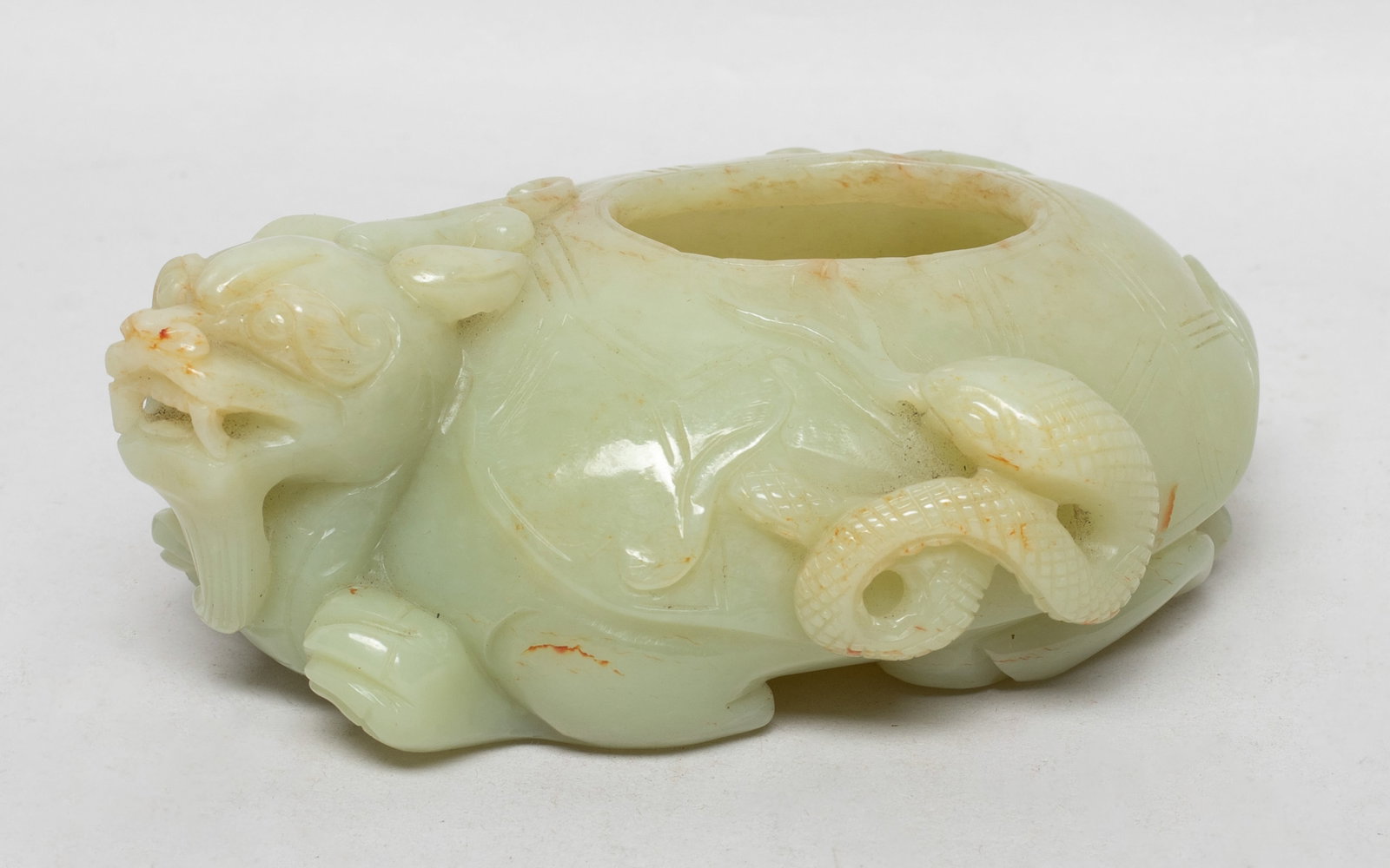Chinese Jade Carved Water Pot: Worked of mysterious horned turtle form, the head slightly looking to the left, a snake coiled on the left side, the back pierced with an aperture, the stone of pale celadon tone with russet inclusion