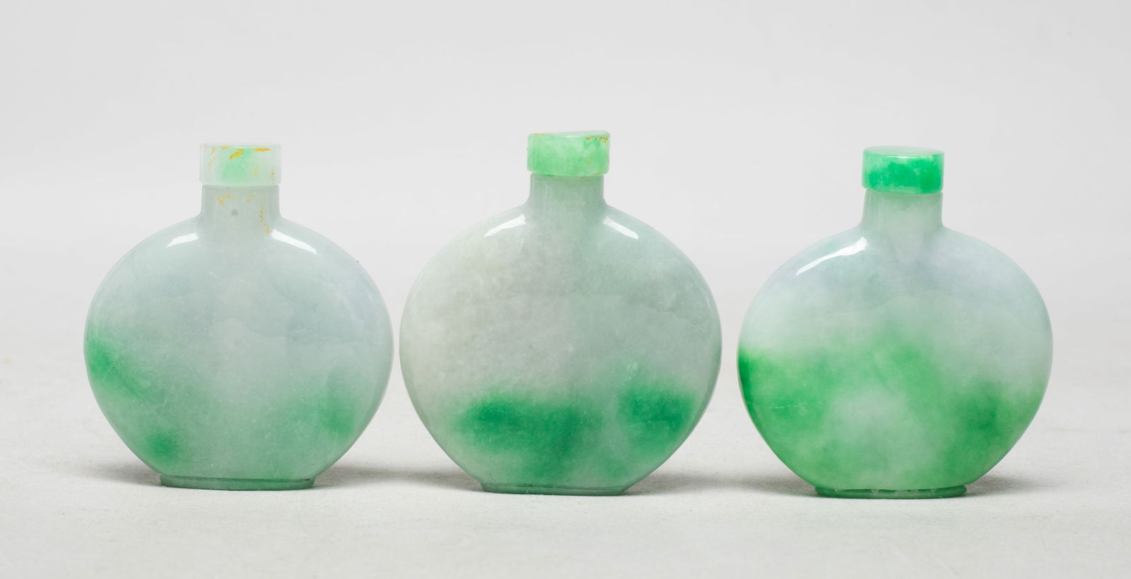 Three Chinese Export Snuff Bottles: Three Chinese colored stone carved snuff bottles, each of flattened ovoid form with a stopper. Approx. 2.2*2.05*0.5 inch (largest w/ stopper).