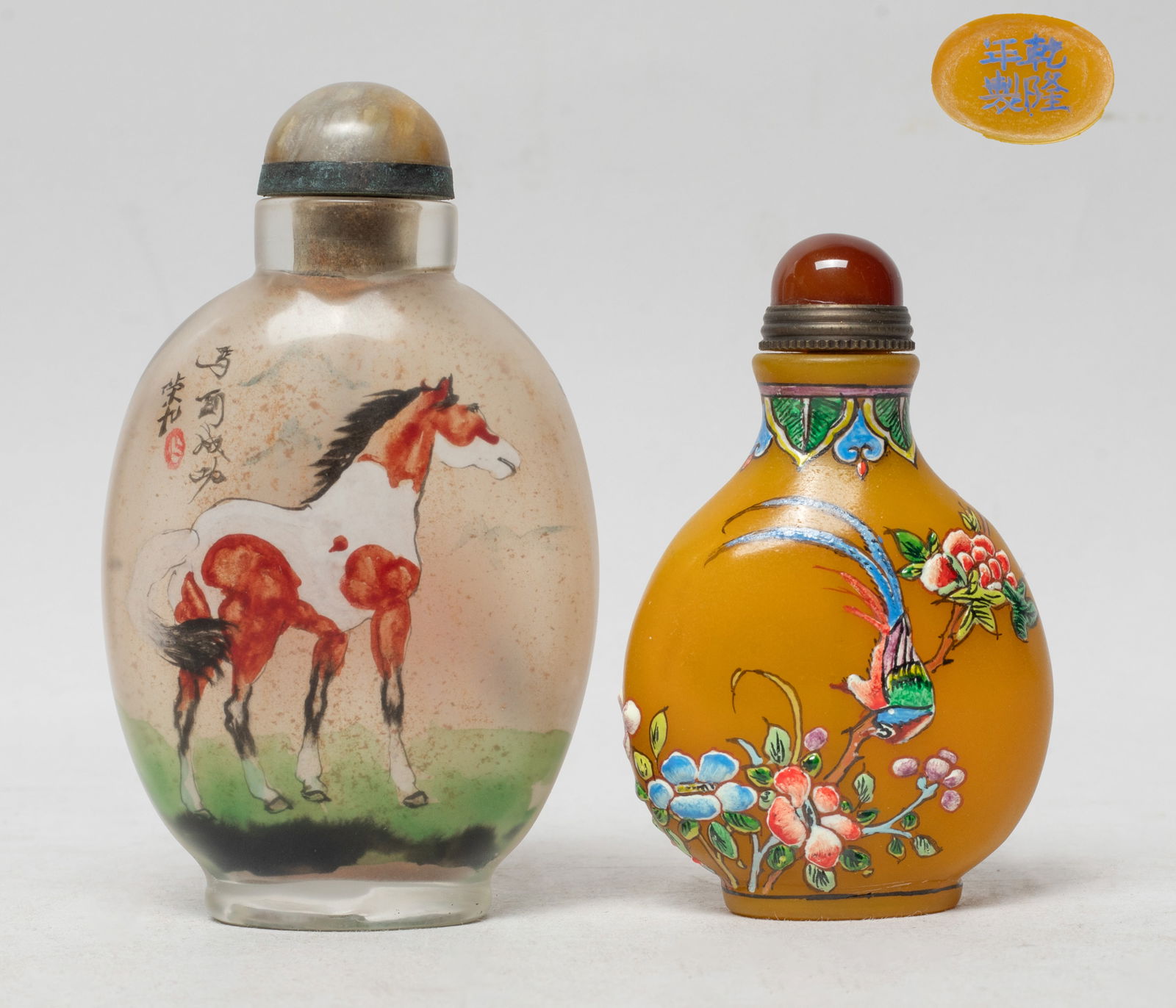 Two Chinese Peiking Glass Snuff Bottles: Both of flattened ovoid form with stoppers, one bottle inside painted with a horse on either side, the other enameled with bird, butterfly and flowers on opaque yellow glass, the bottom marked with fo