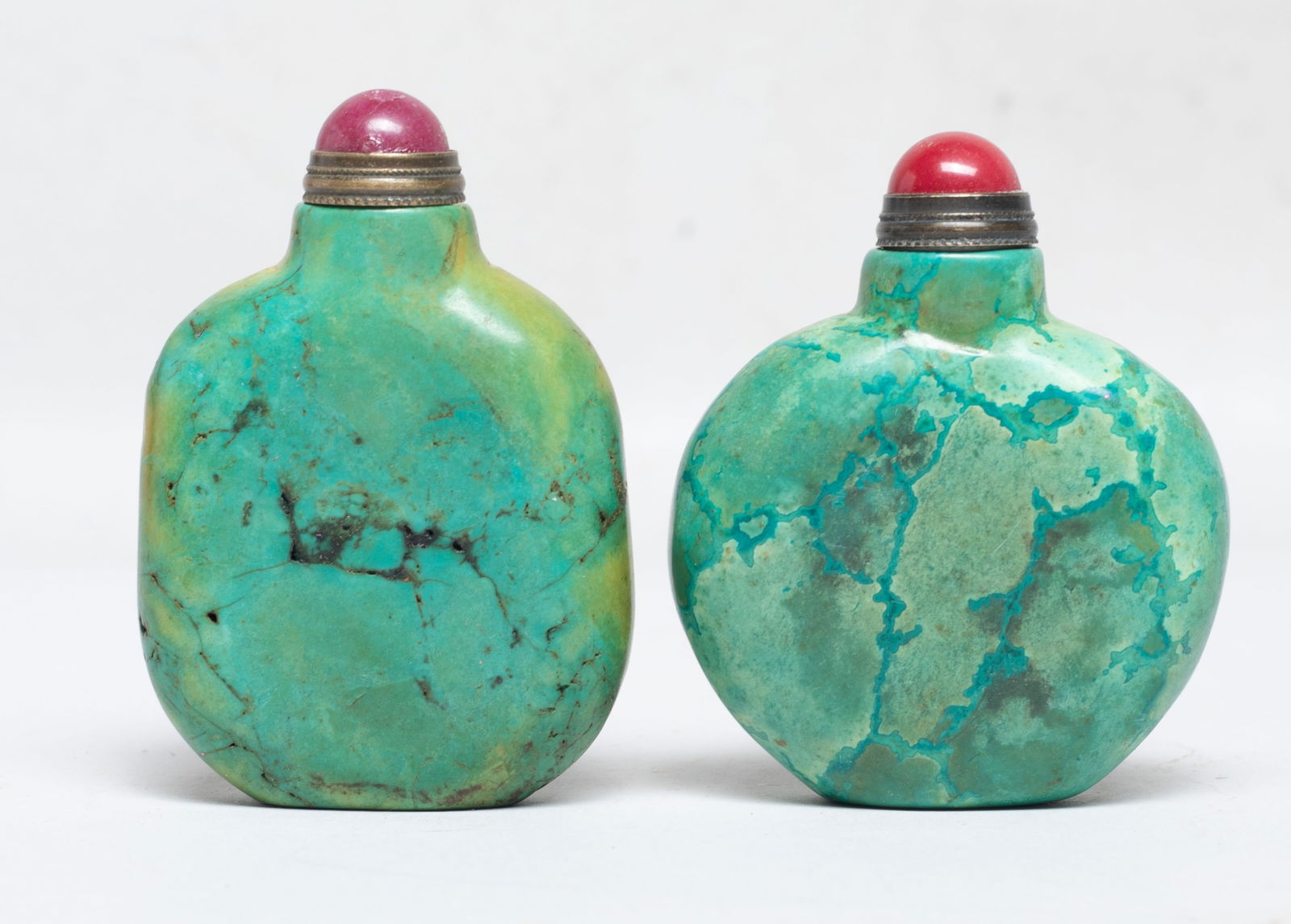 Two Chinese Turquoise Like Snuff Bottles: Two Chinese turquoise-like stone carved snuff bottles, of flattened form, each with a stone stopper. Approx. 2.57*1.78*0.7 inch (larger w/ stopper).