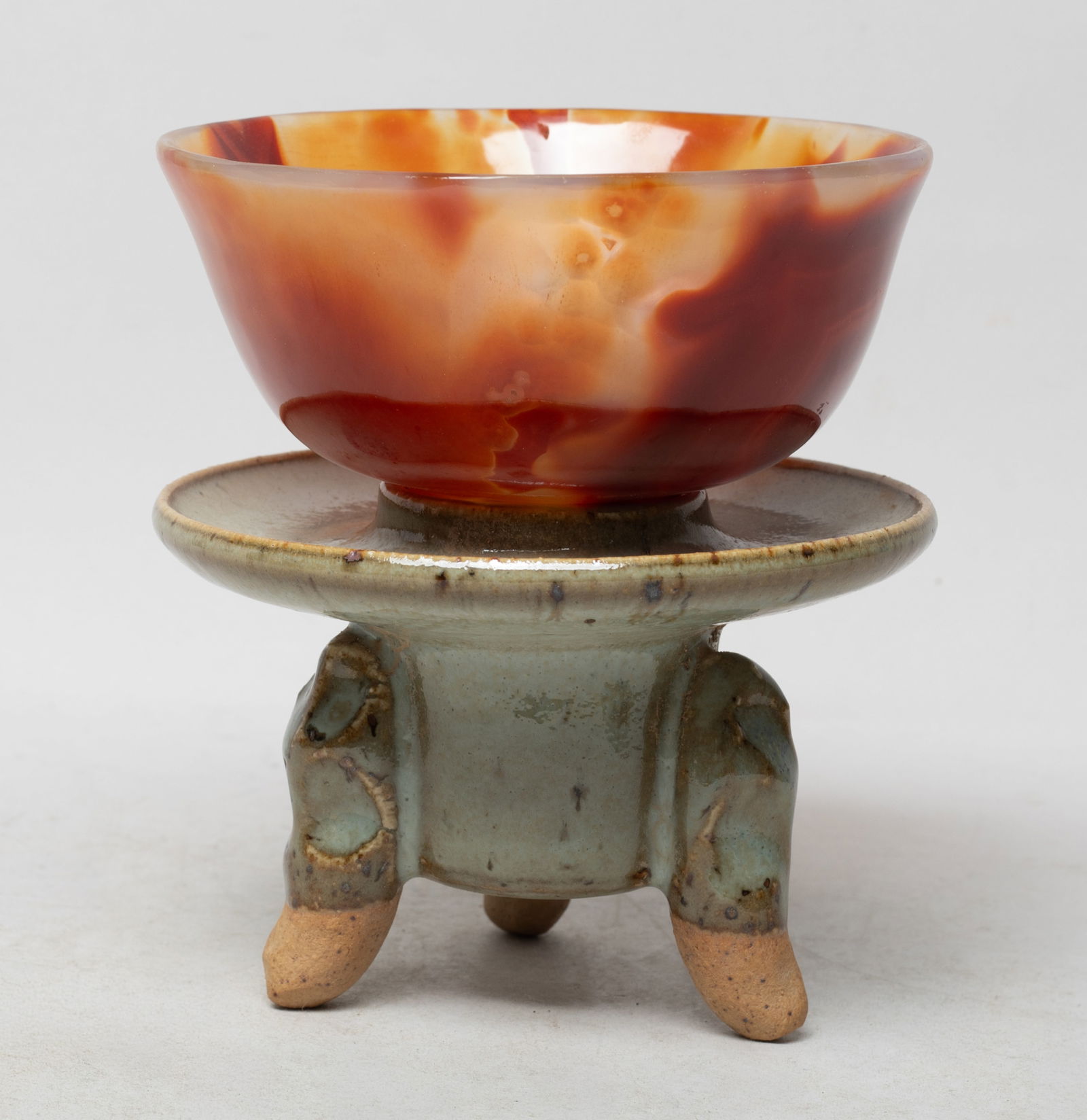 Chinese Export Agate Bowl w/ Porcelain Base: Collectible Chinese agate bowl, the surface finely smoothed, the porcelain stand applied with bubbled mottled greenish gray glaze. Approx. 4.85*2.4 inch (bowl size).