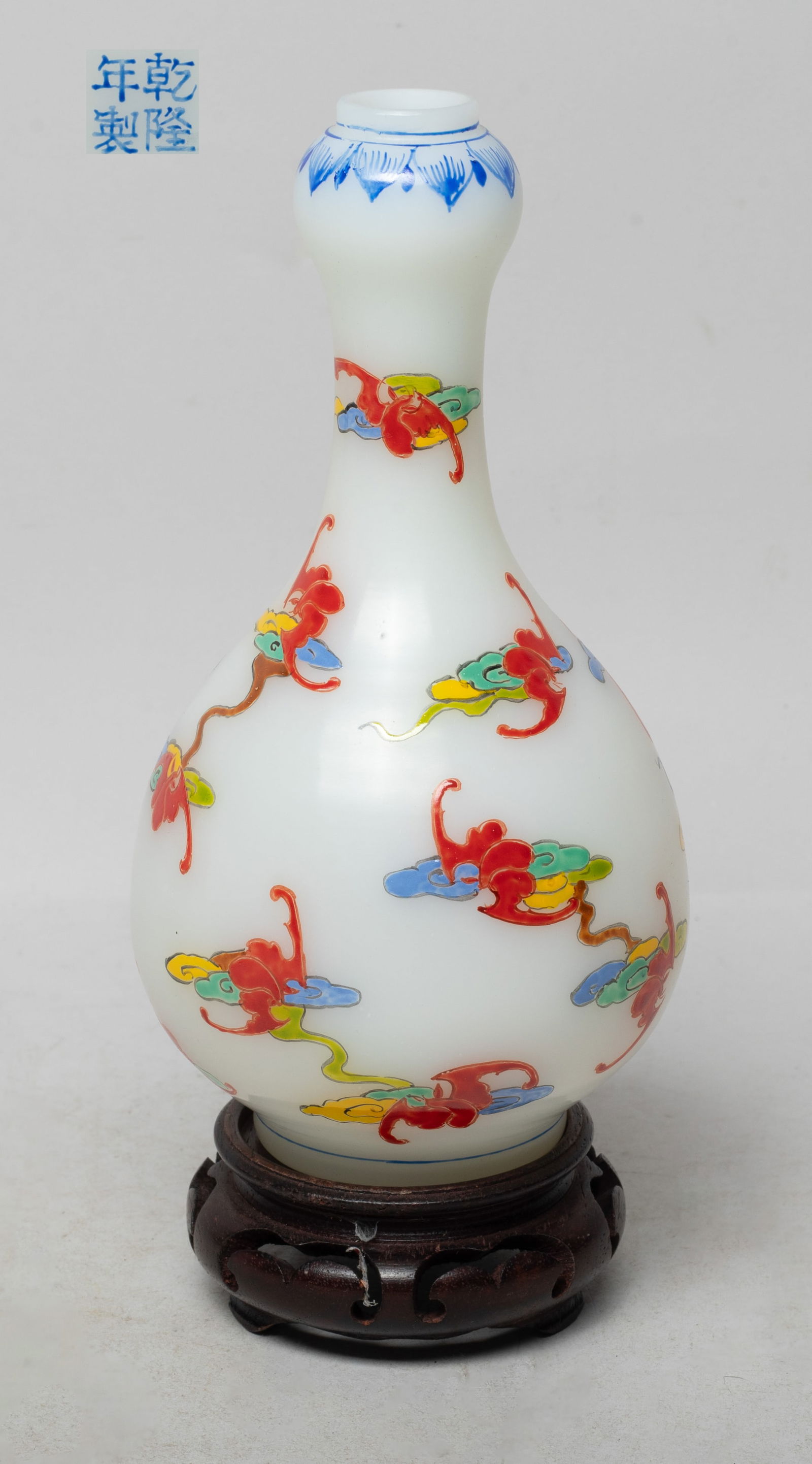 Estate Chinese Enameled Jade Like Glass Vase: The pear shaped body rising from a short foot to a cylindrical neck and a garlic mouth, the exterior enameled with bats among clouds, under a band of lotus petals at the mouth, the bottom marked with