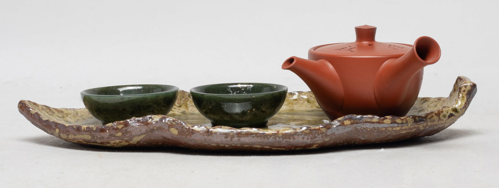 Vintage Asian Porcelain, Jade Tea Wares: Including a leaf form porcelain plate, a water pot, and two spinach jade carved tea cups. Approx. 9*4.3 inch (plate size).