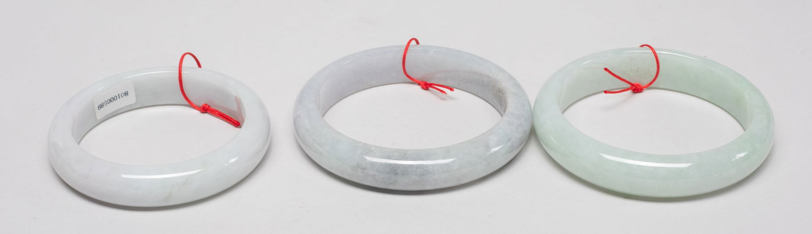 Three Chinese Export Jade Bangles: Set of three Chinese jade bangles. Approx. 3.05 inch outer diameter, 2.47 inch inner diameter (largest).