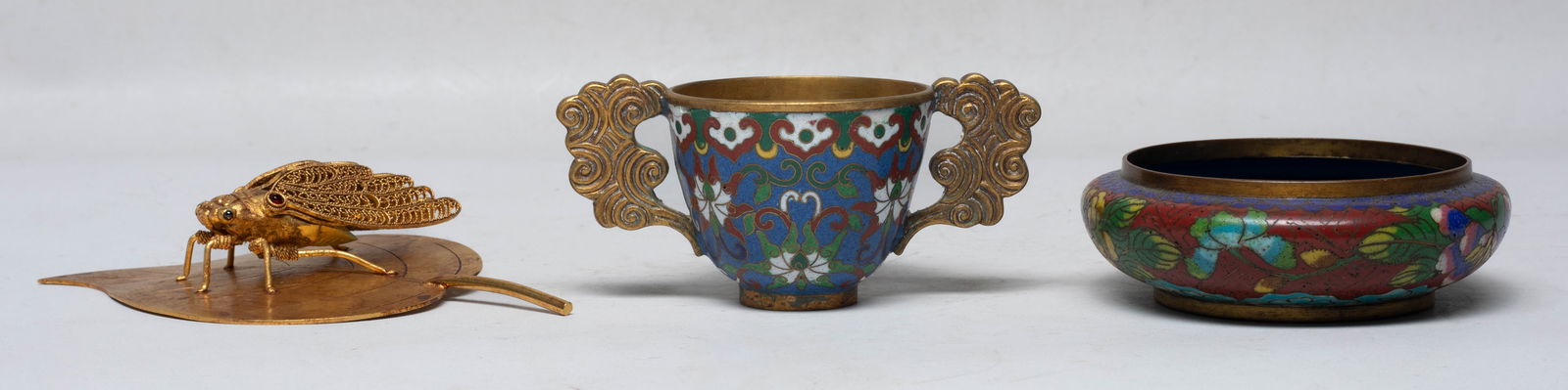Estate Chinese Brass/ Metal Pieces: Including a cloisonne washer enameled with flowers on red ground, a cup enameled lotus on blue ground, with two clouds form handles, and a sculpture cast as a cicada on a leaf, the bottom marked four